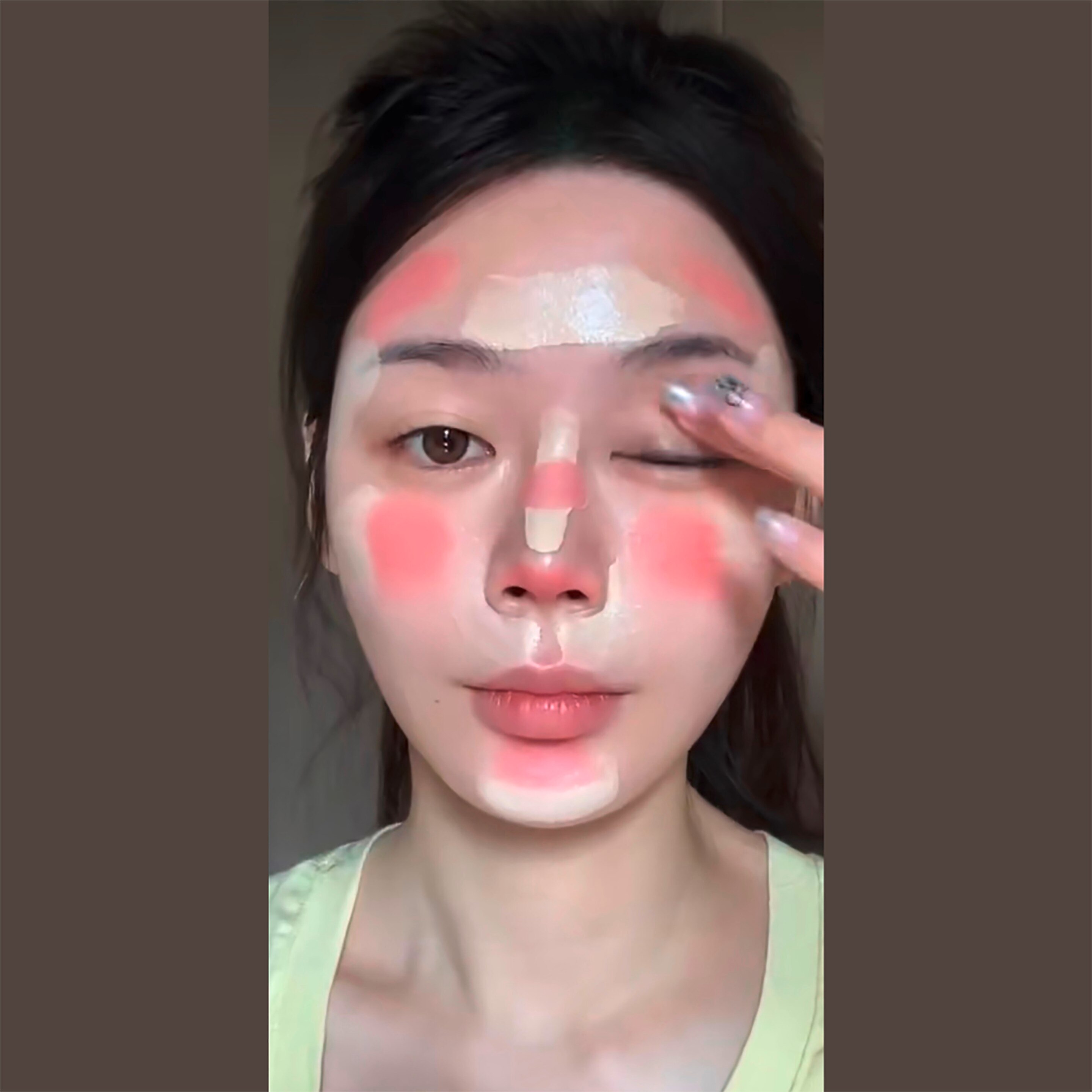 Woman applying blush and foundation to her face.