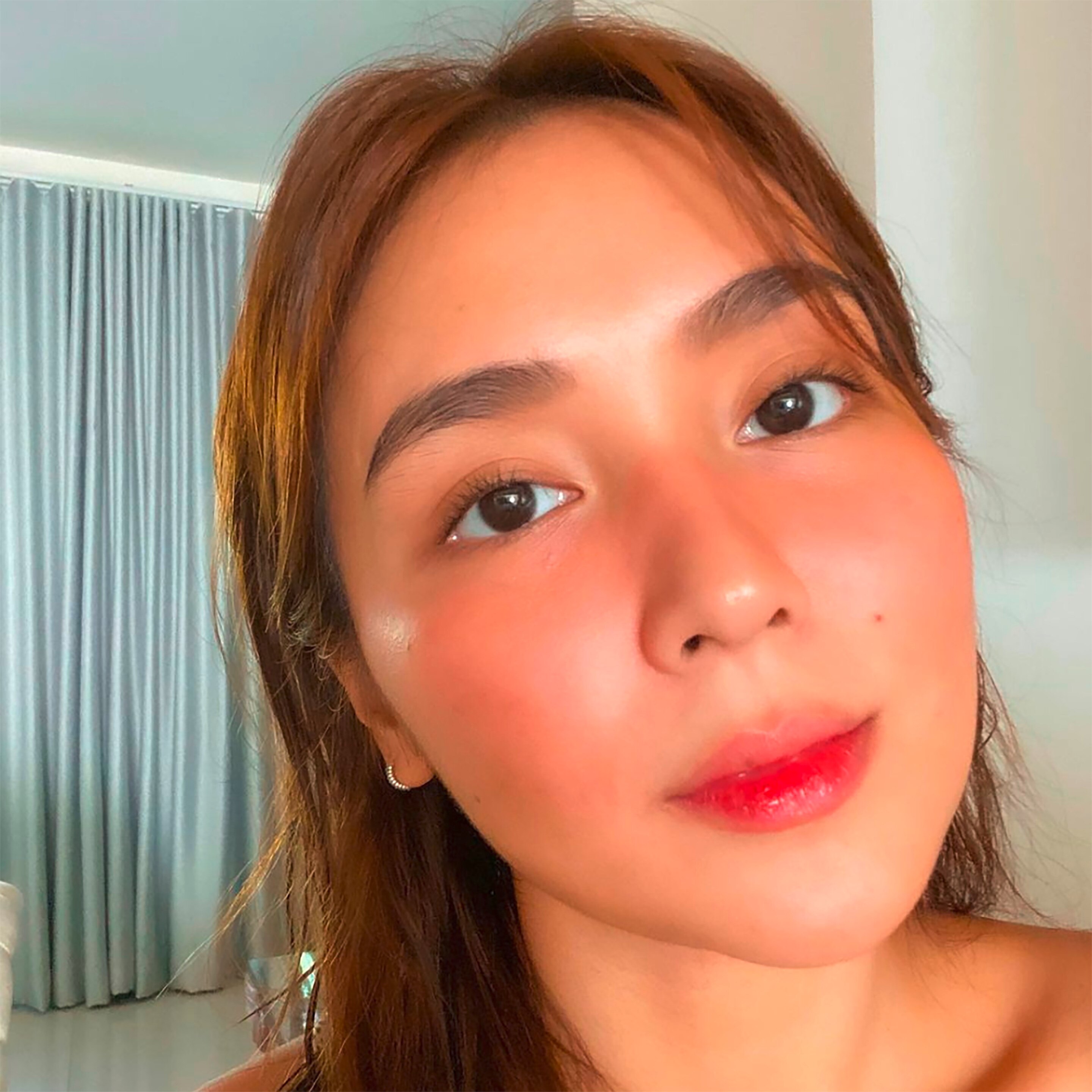 A portrait of Kat Bernado with pink blush and pink lips.