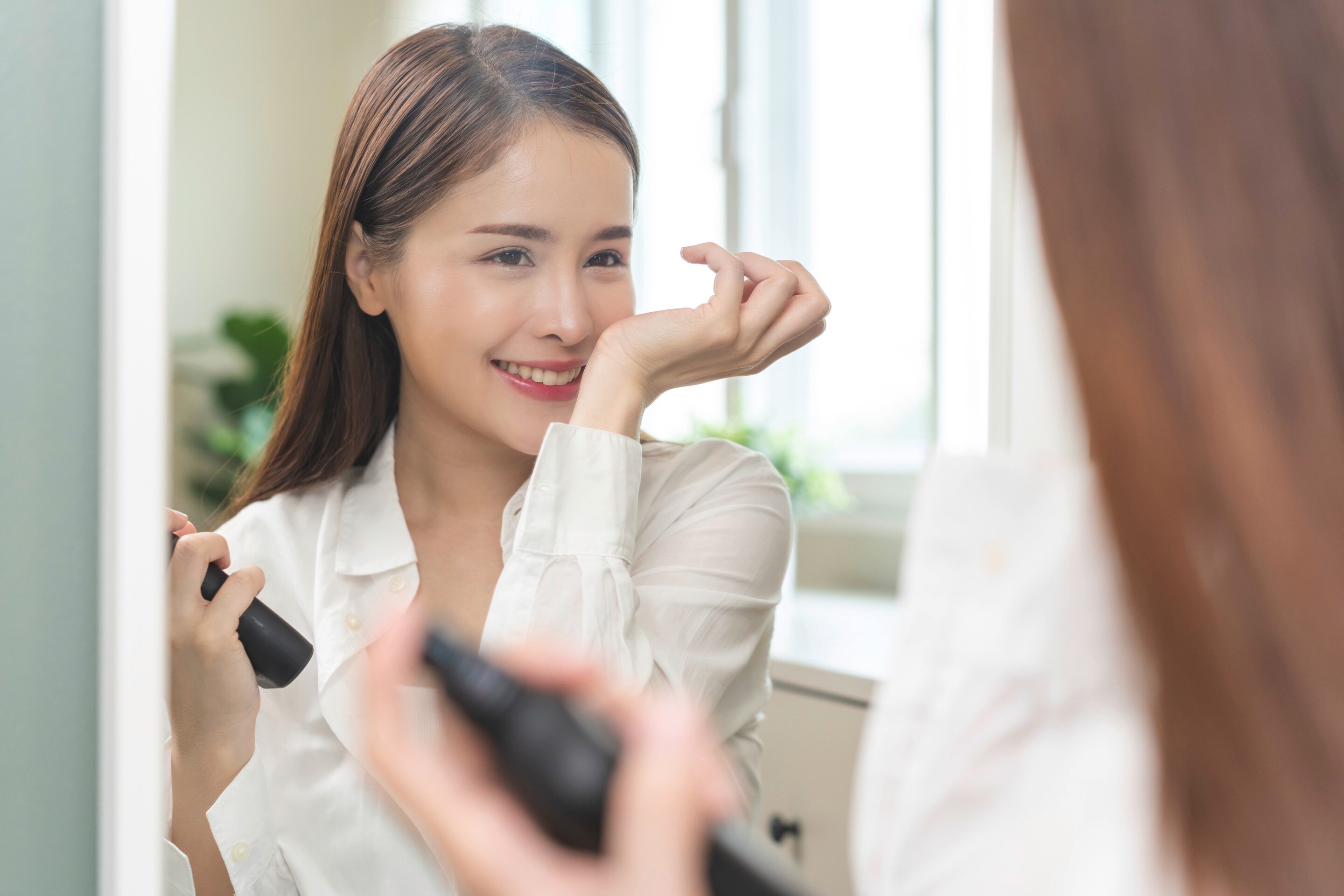 Woman smelling the perfume scent on her wrist.