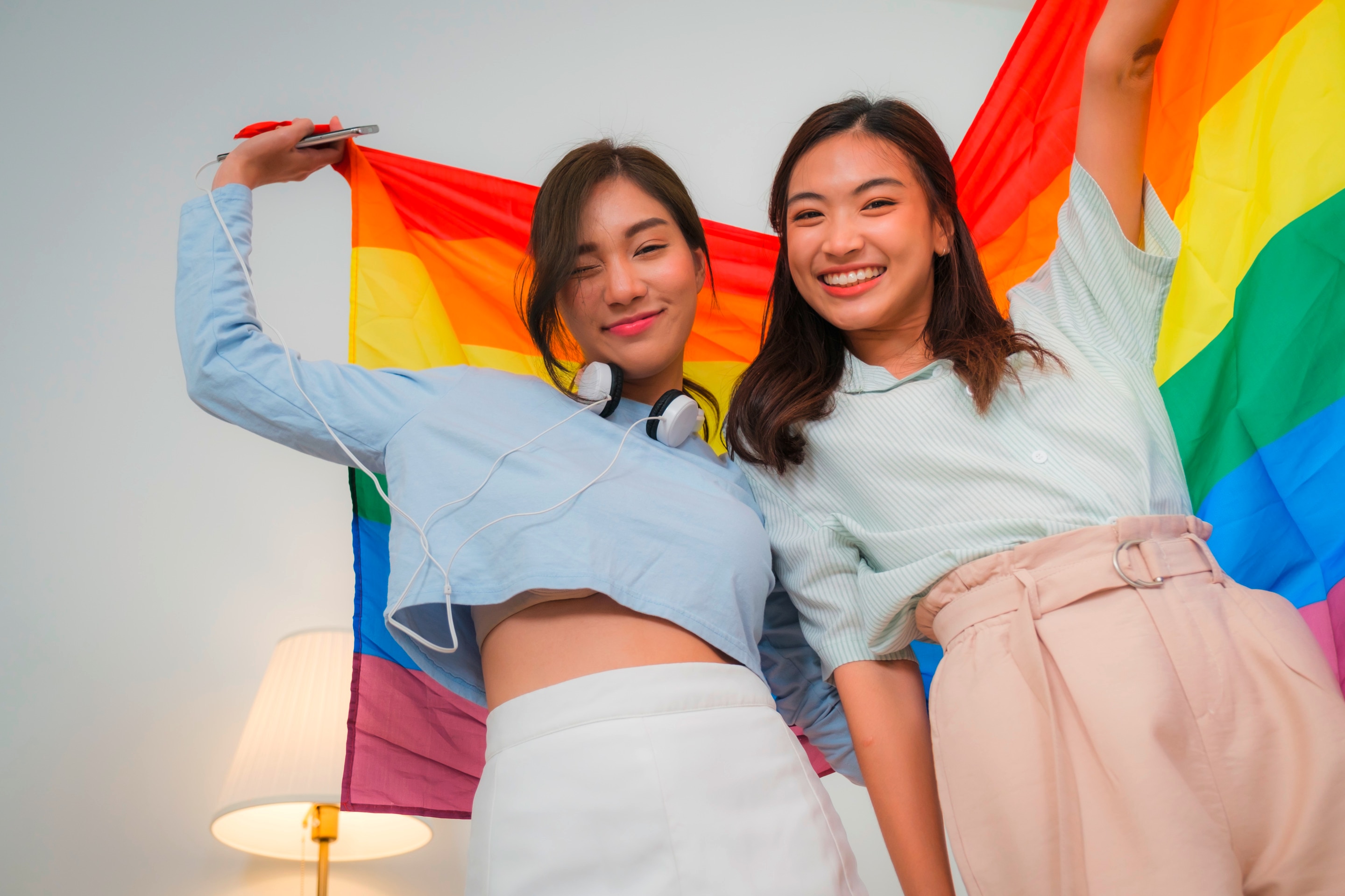Lesbian couple holding a pride flag.