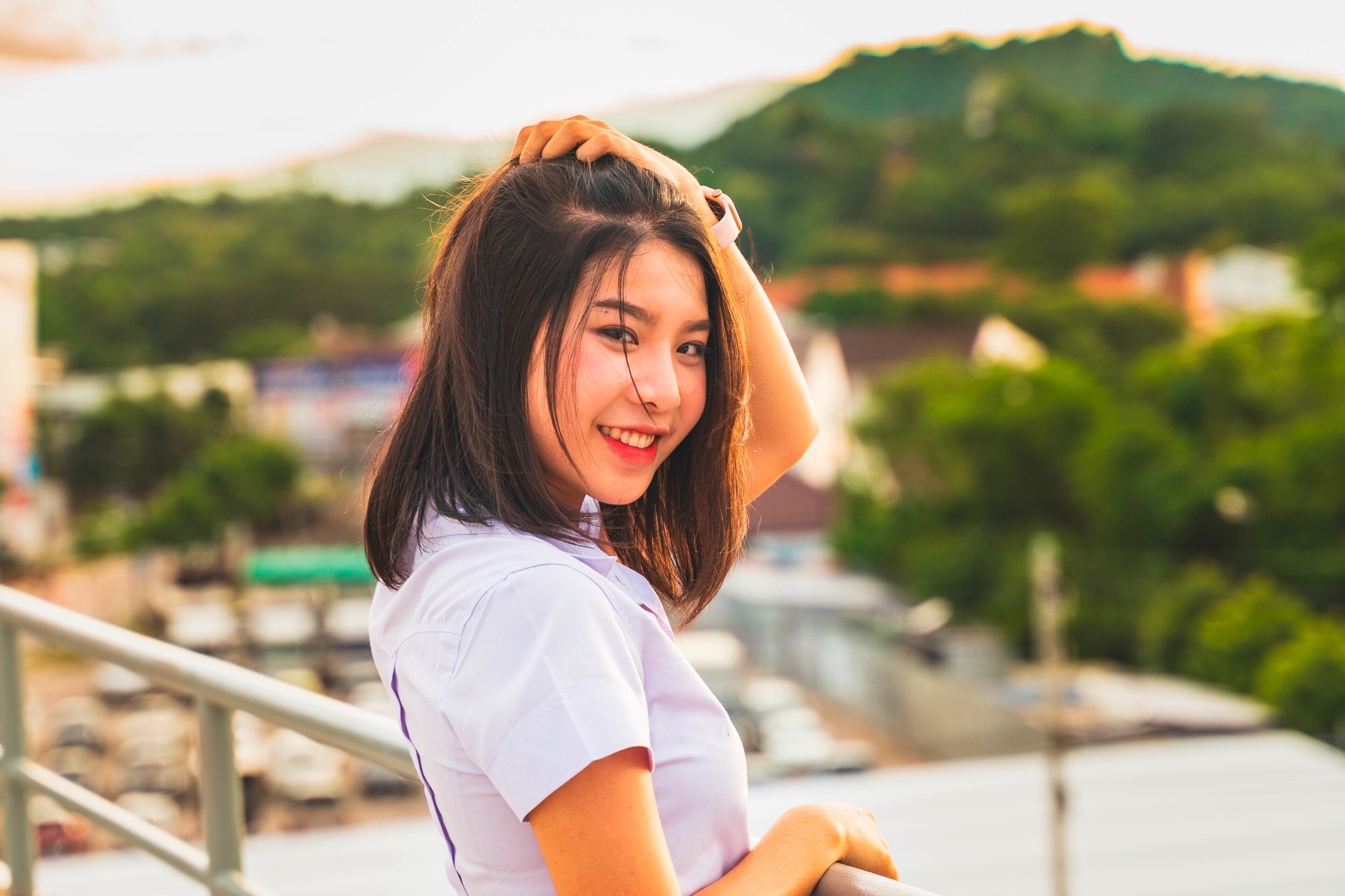 Smiling woman with sweat-proof makeup running her fingers through her hair.