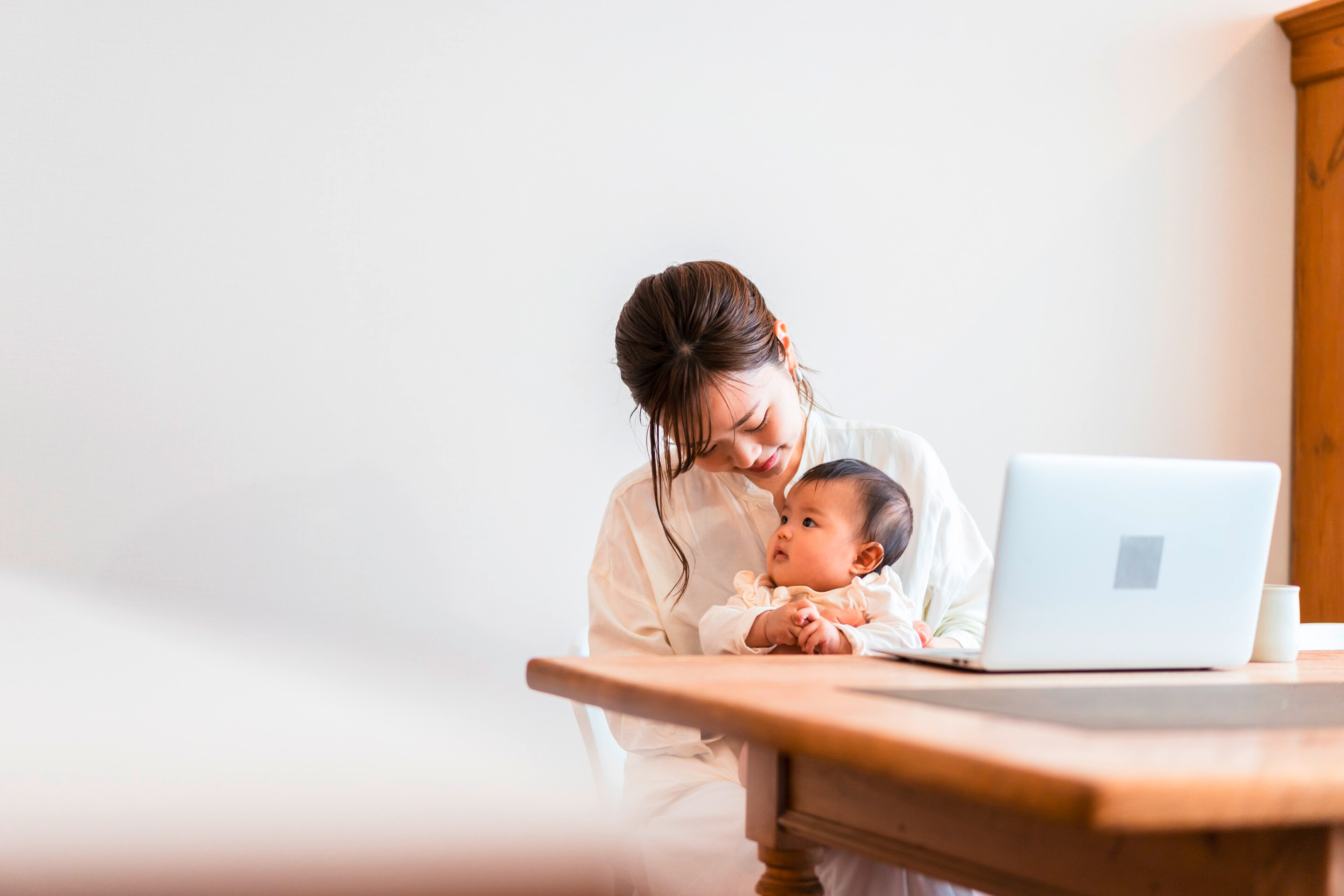 Mom on laptop with baby.