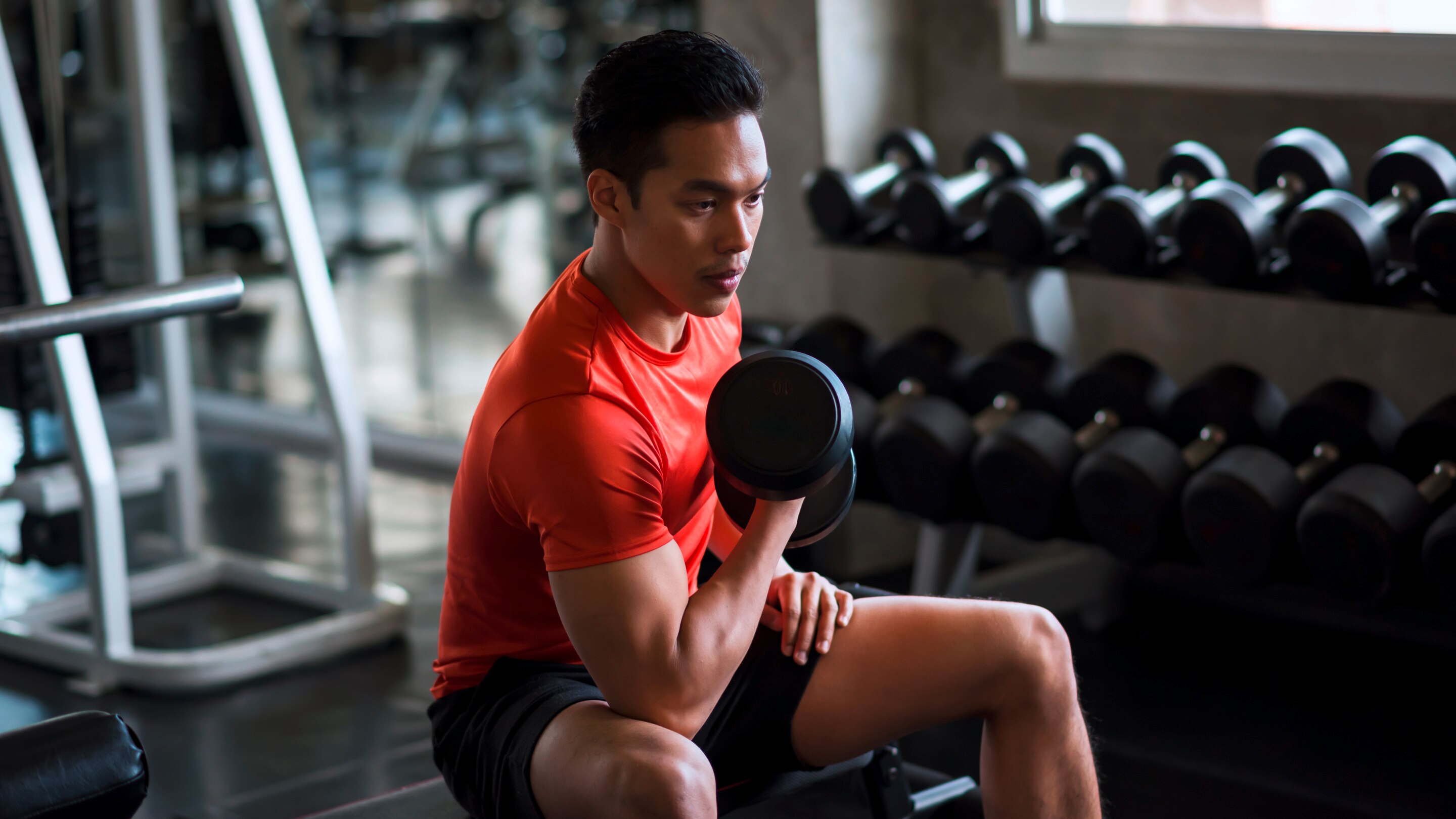 Man lifting barbell in front of mirror.