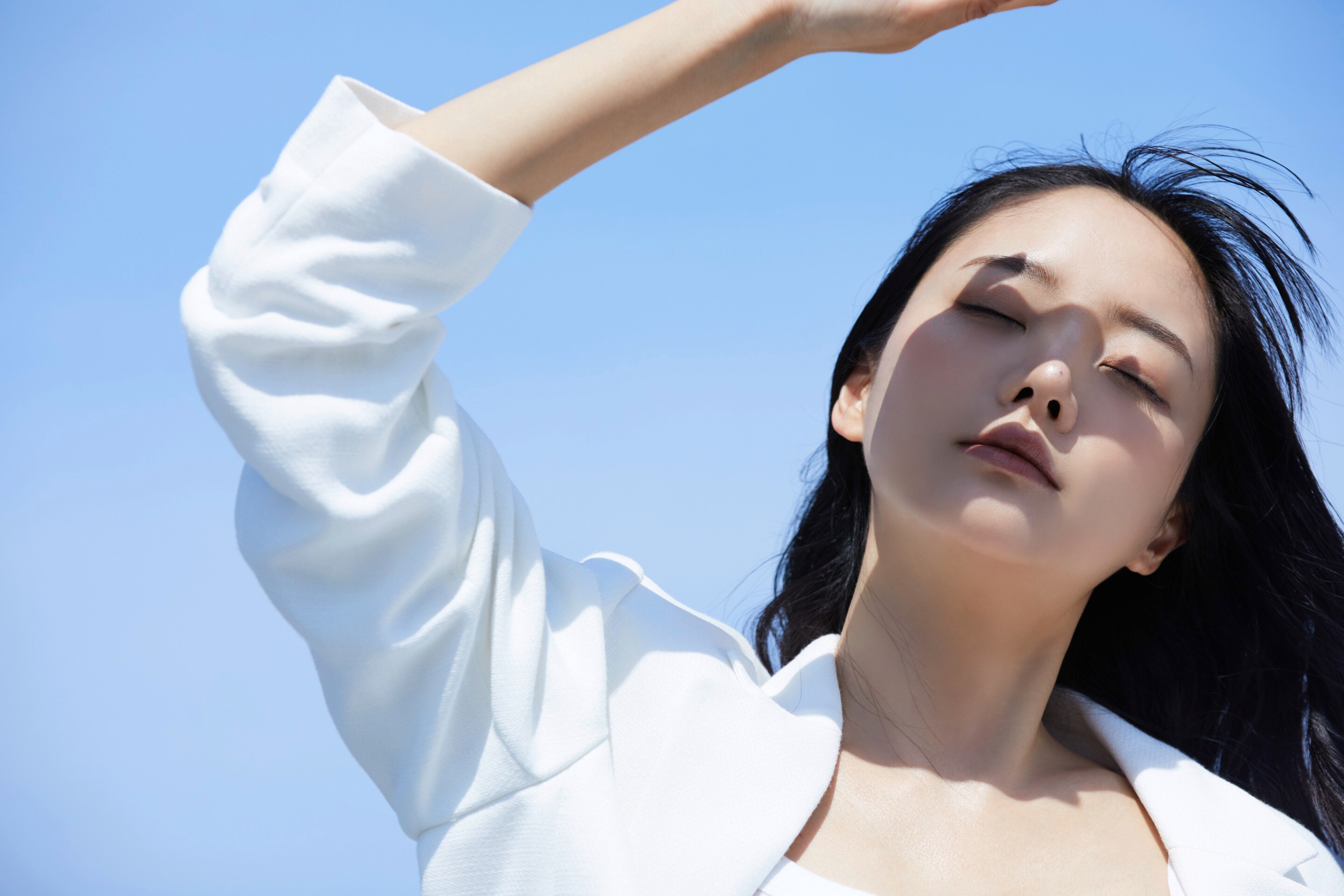 Woman shielding her face from the sun.