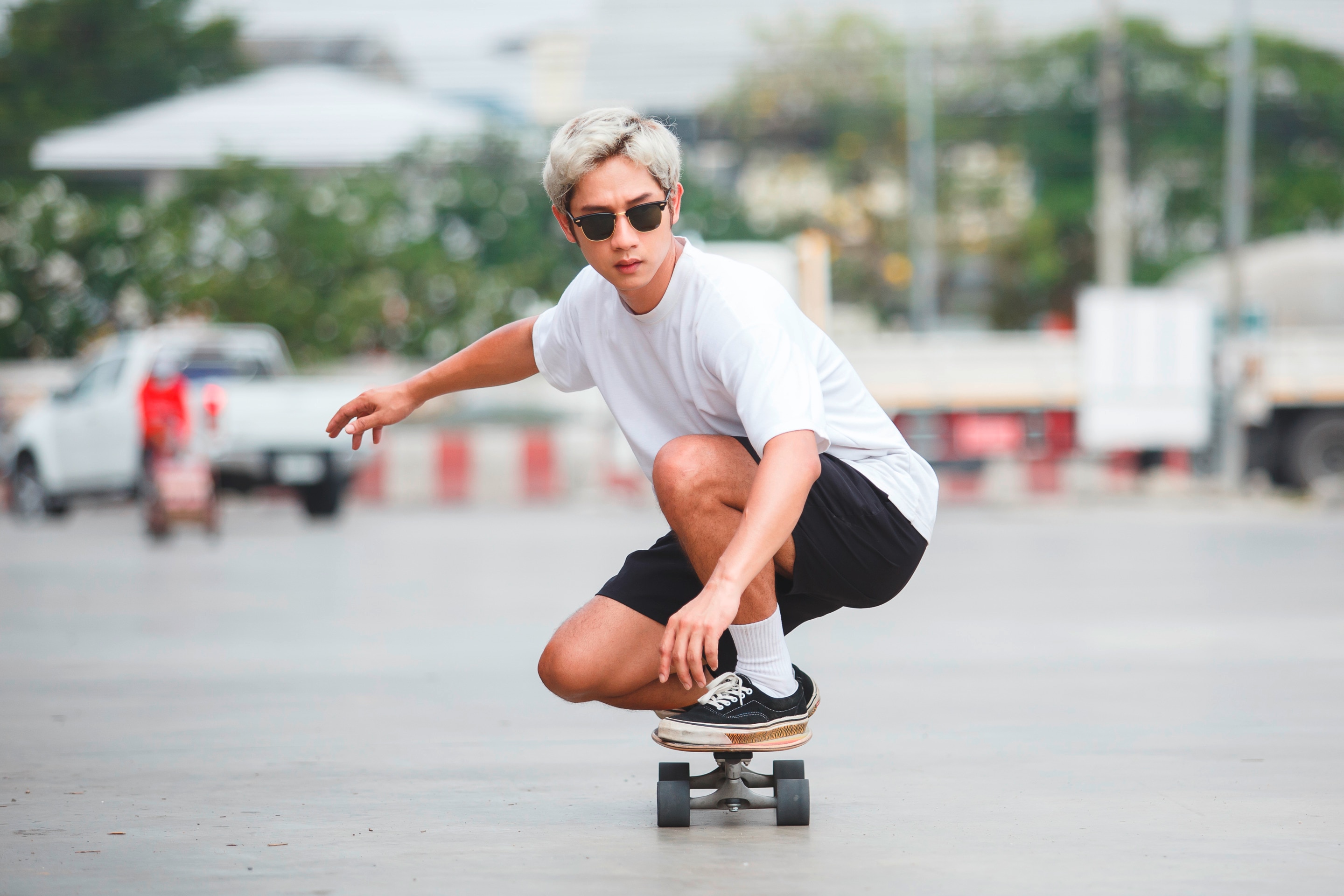Man with sunglasses on riding a skateboard.