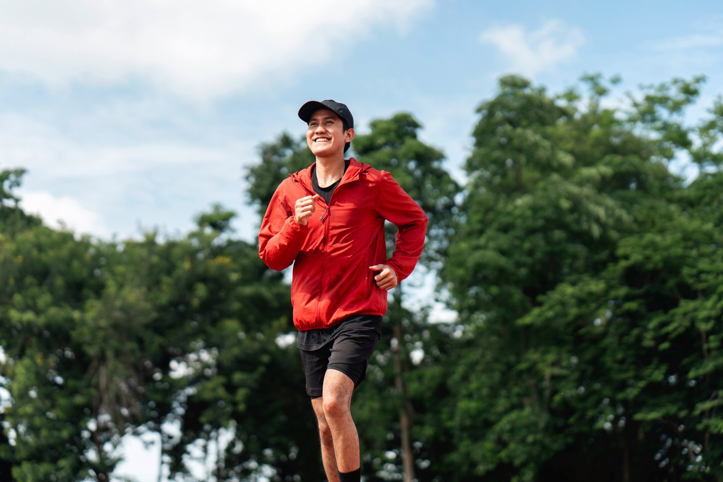Smiling man in sportswear running outdoors.