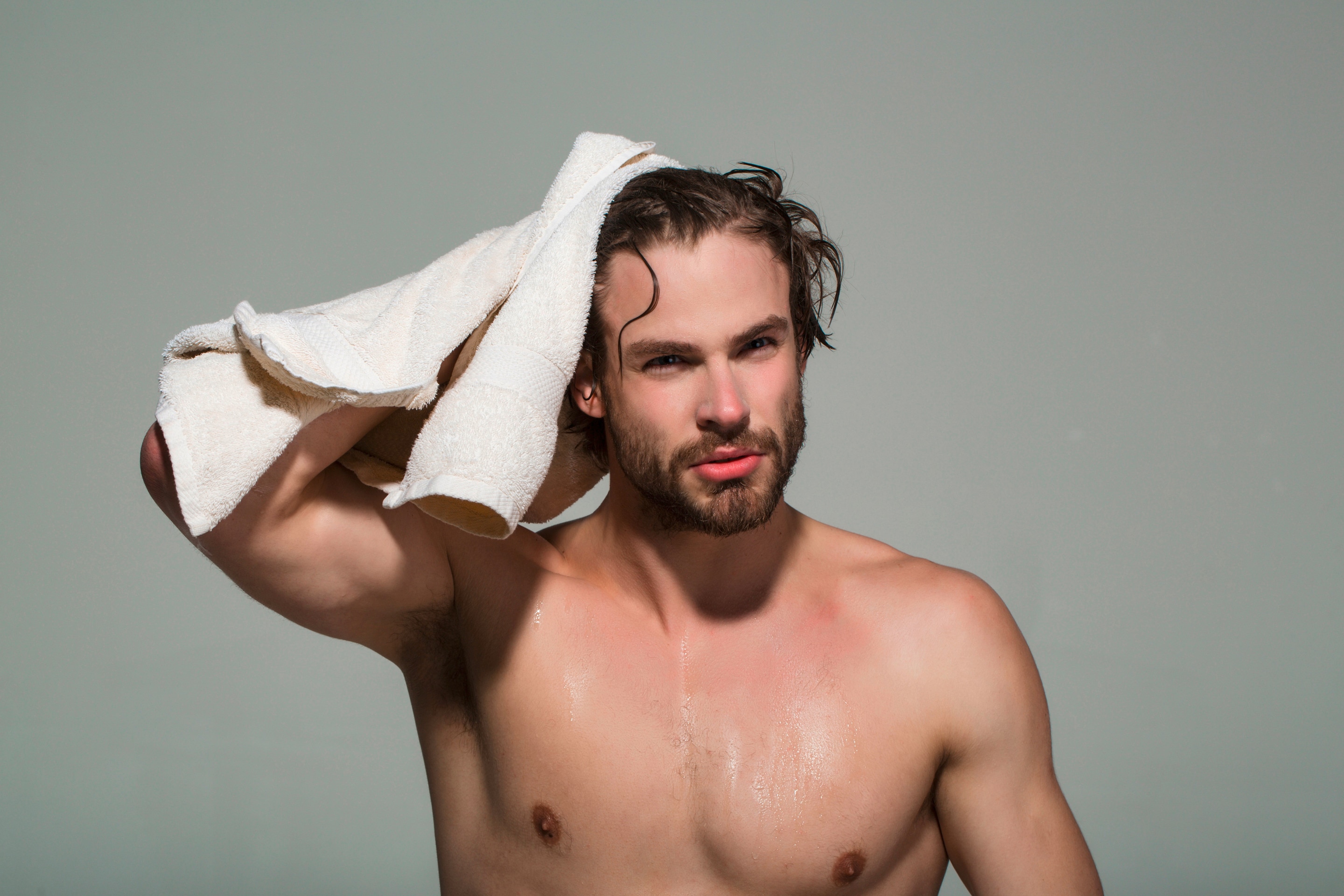 ผู้ชายฝรั่ง ผมหยักศก ผมดัดลอน สระผมมา ใช้ผ้าขนหนูสีขาวเช็ดผม 