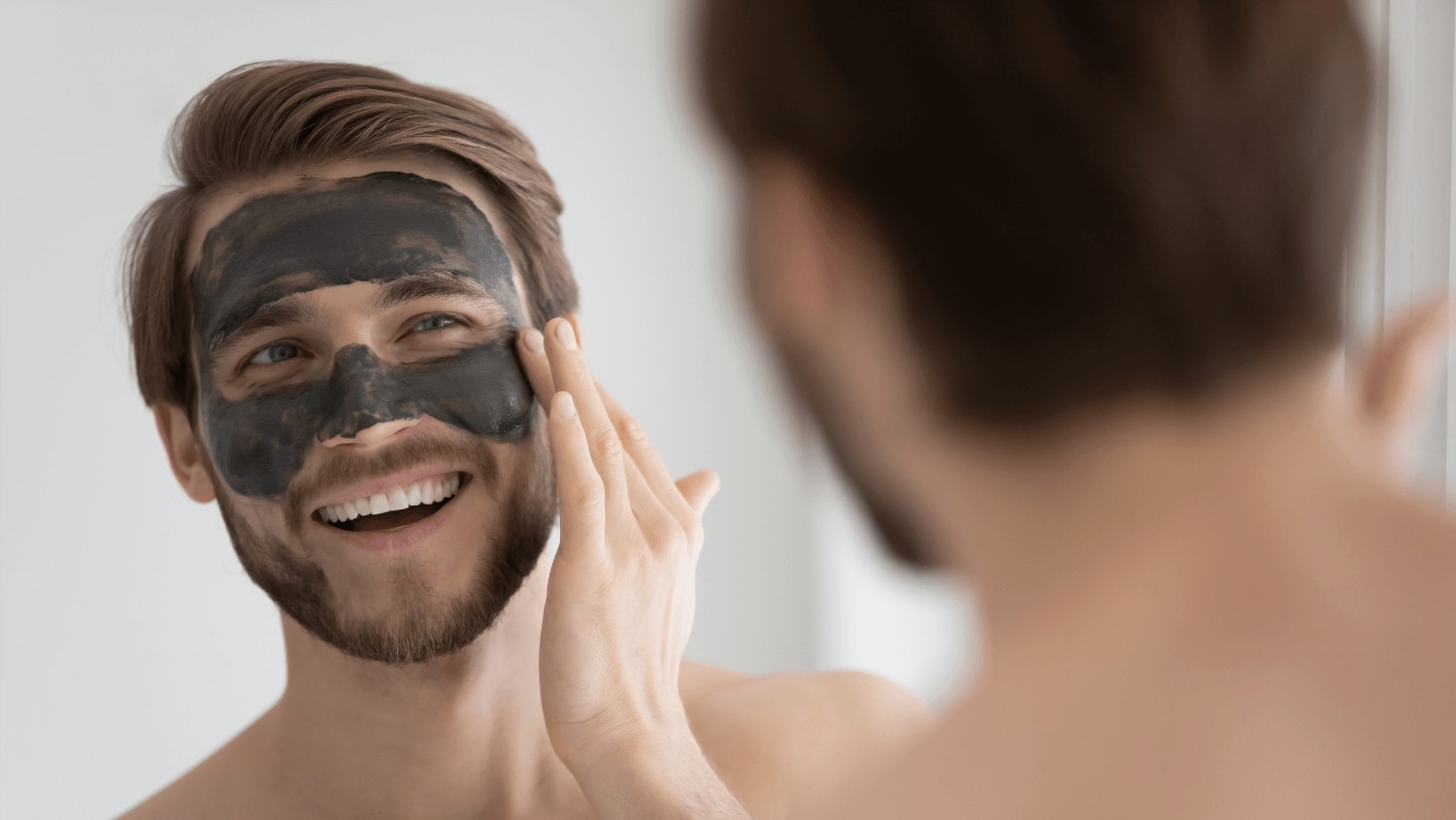 Young man using charcoal on his skin to remove impurities