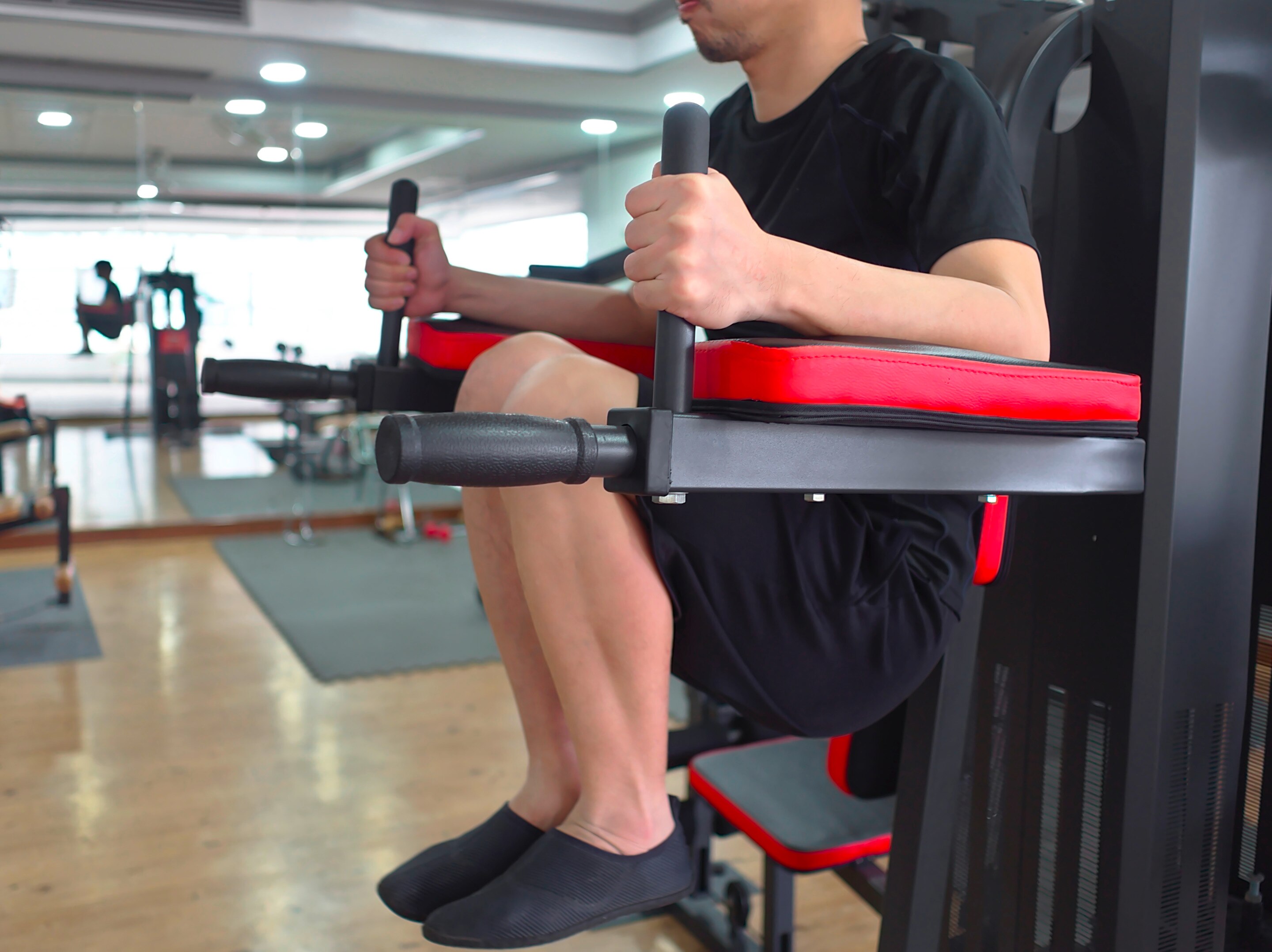 Man doing a knee raise on a captain’s chair.