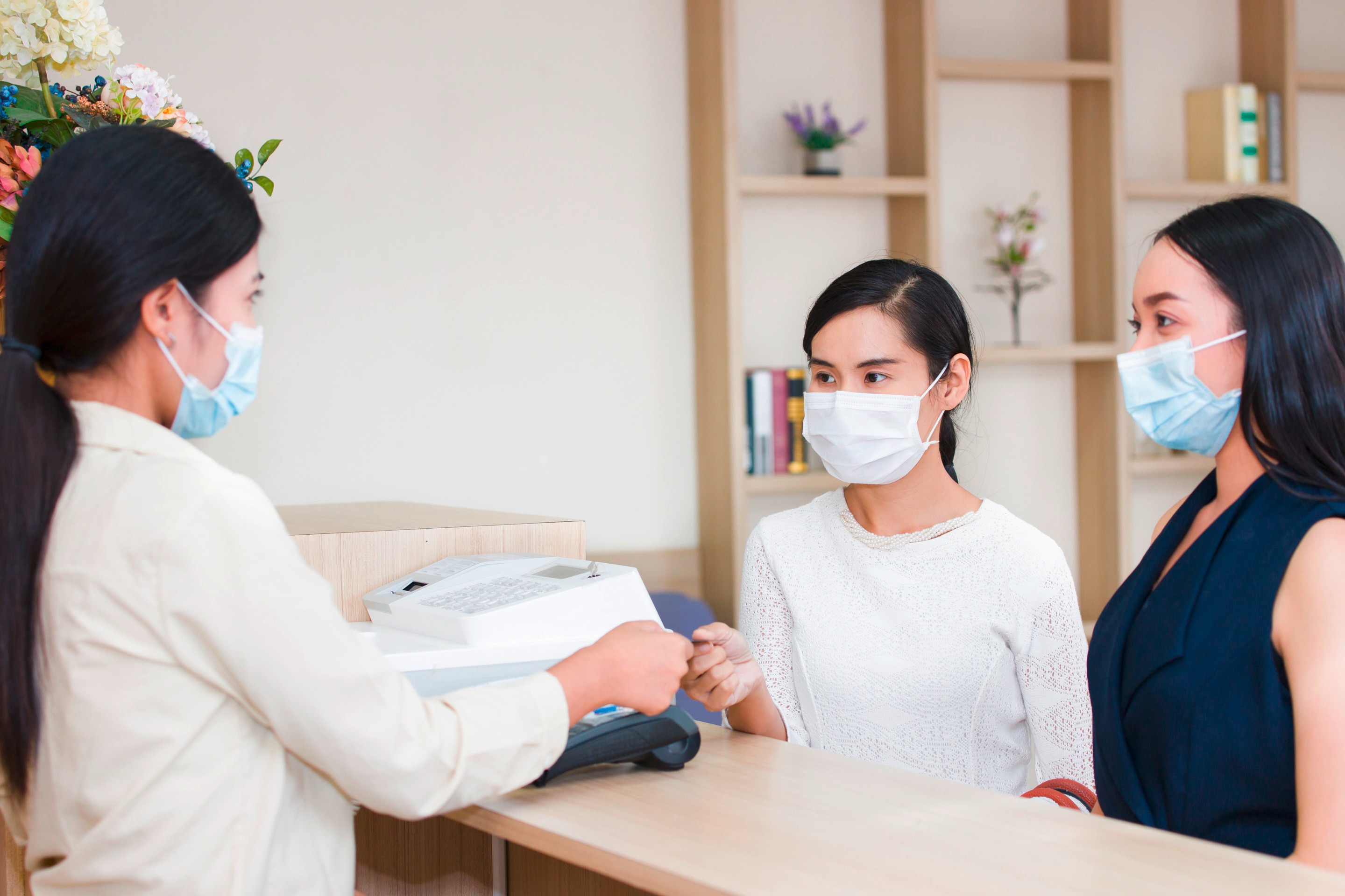 Mom and daughter paying bill at clinic.