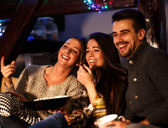 Friends enjoying a dessert charcuterie board on movie-night