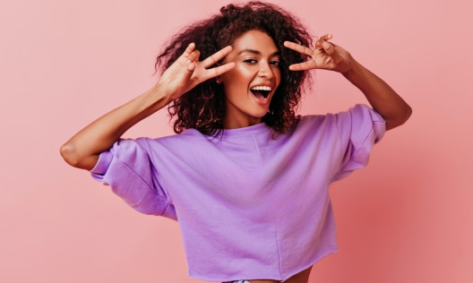 Happy confident beautiful African American woman posing with peace signs and no sign of strong body odor