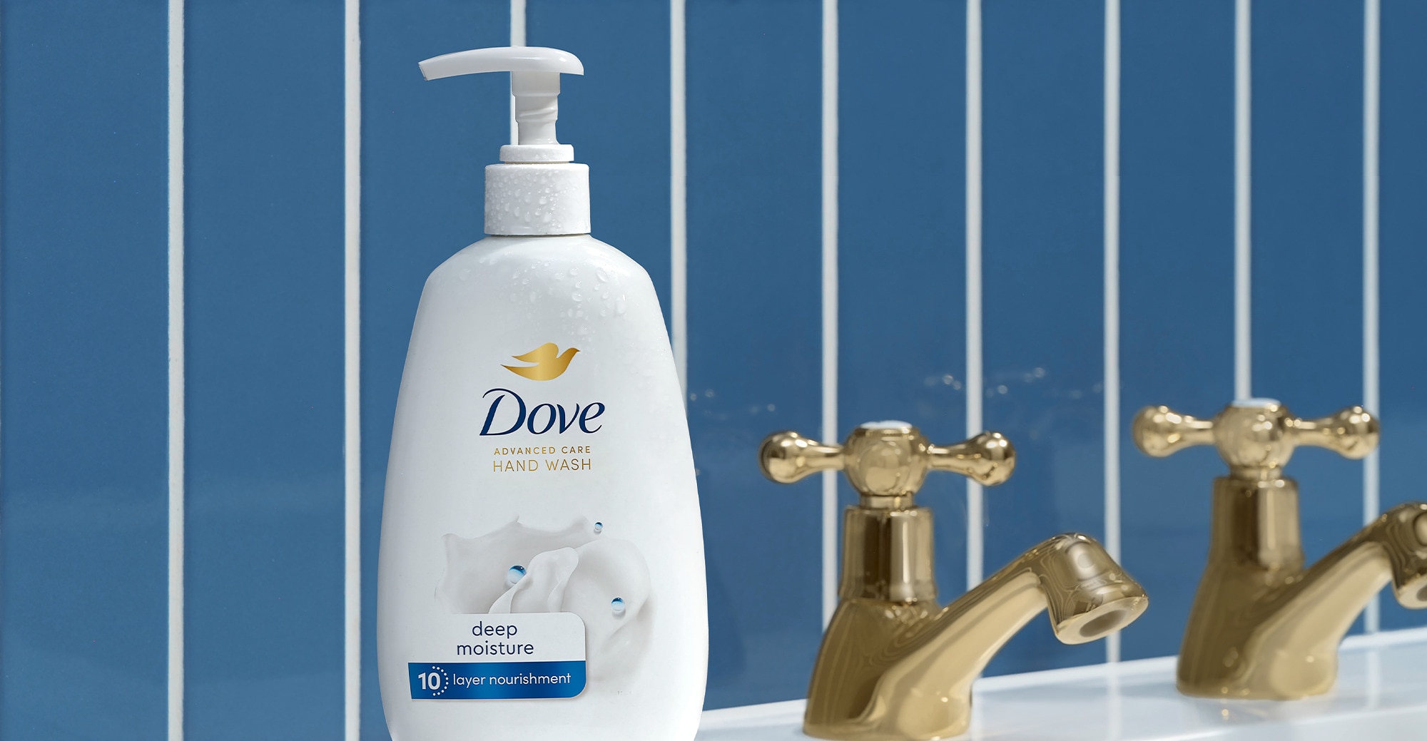 Dove Deep Moisture Hand Wash sitting on a sink against a blue tiled background