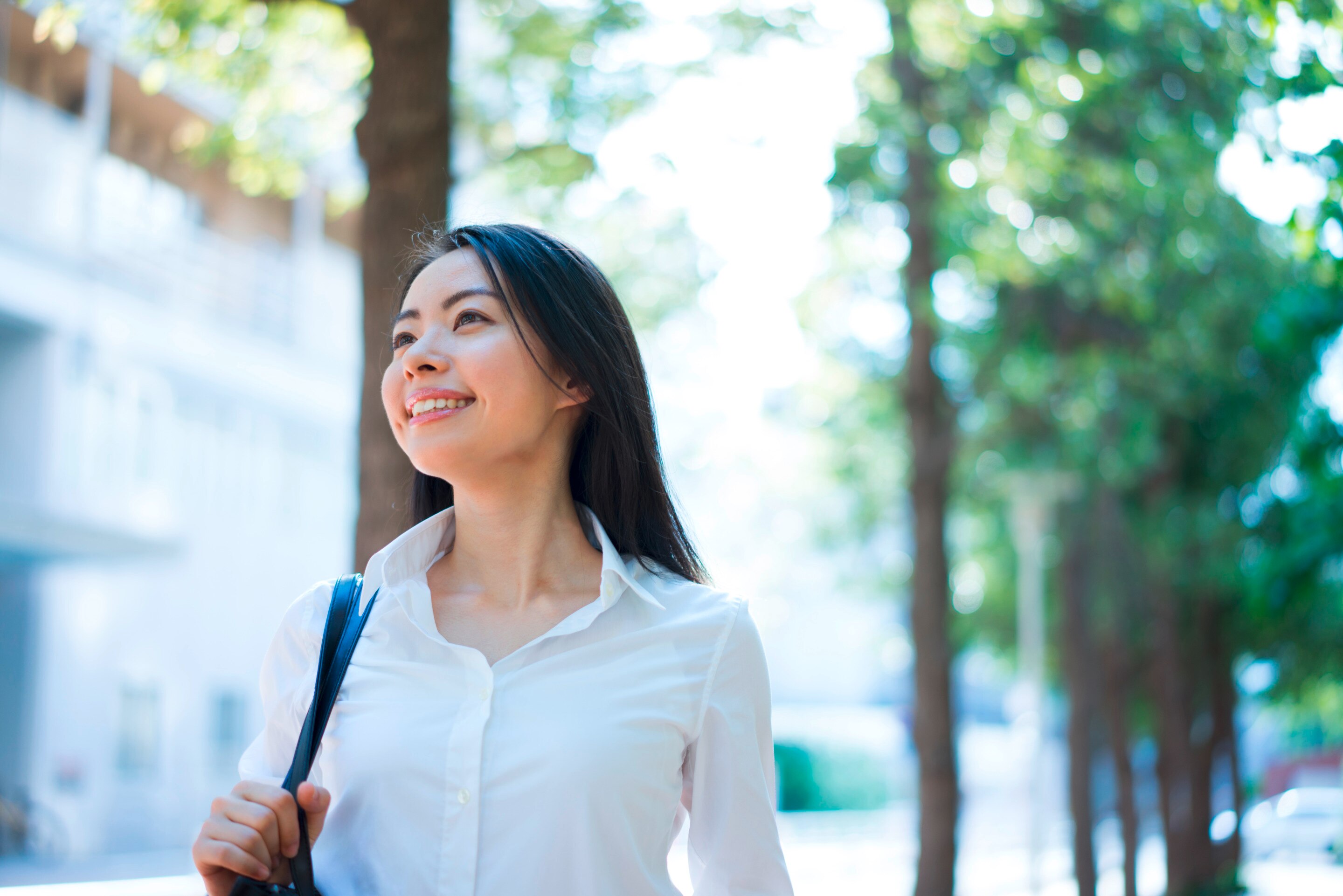 Asian woman walking to work outdoors.