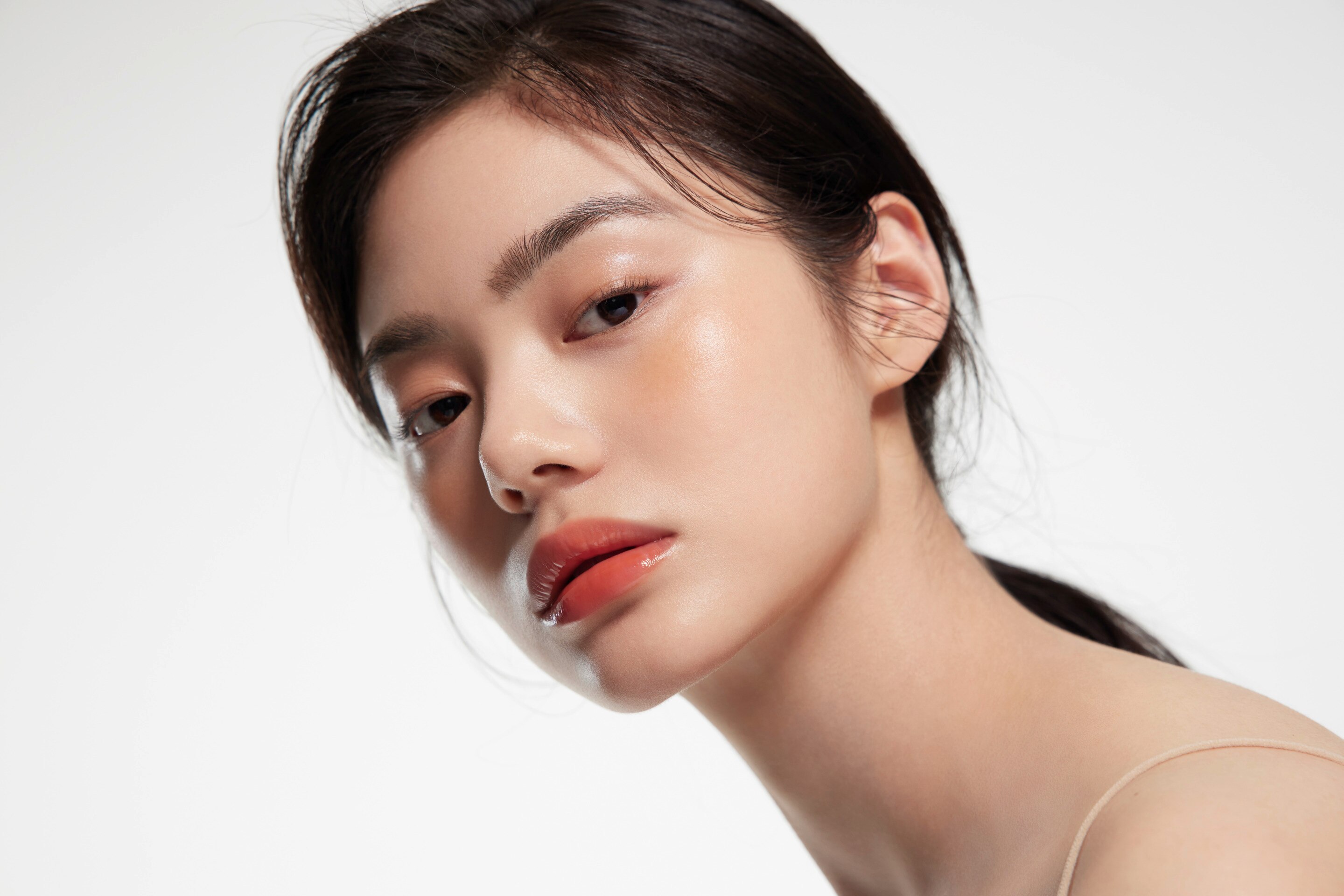 ผู้หญิงเอเชีย ผมแสกข้าง รวบหางม้าต่ำ ผิวสวย สวมเสื้อสายสปาเก็ตตี้