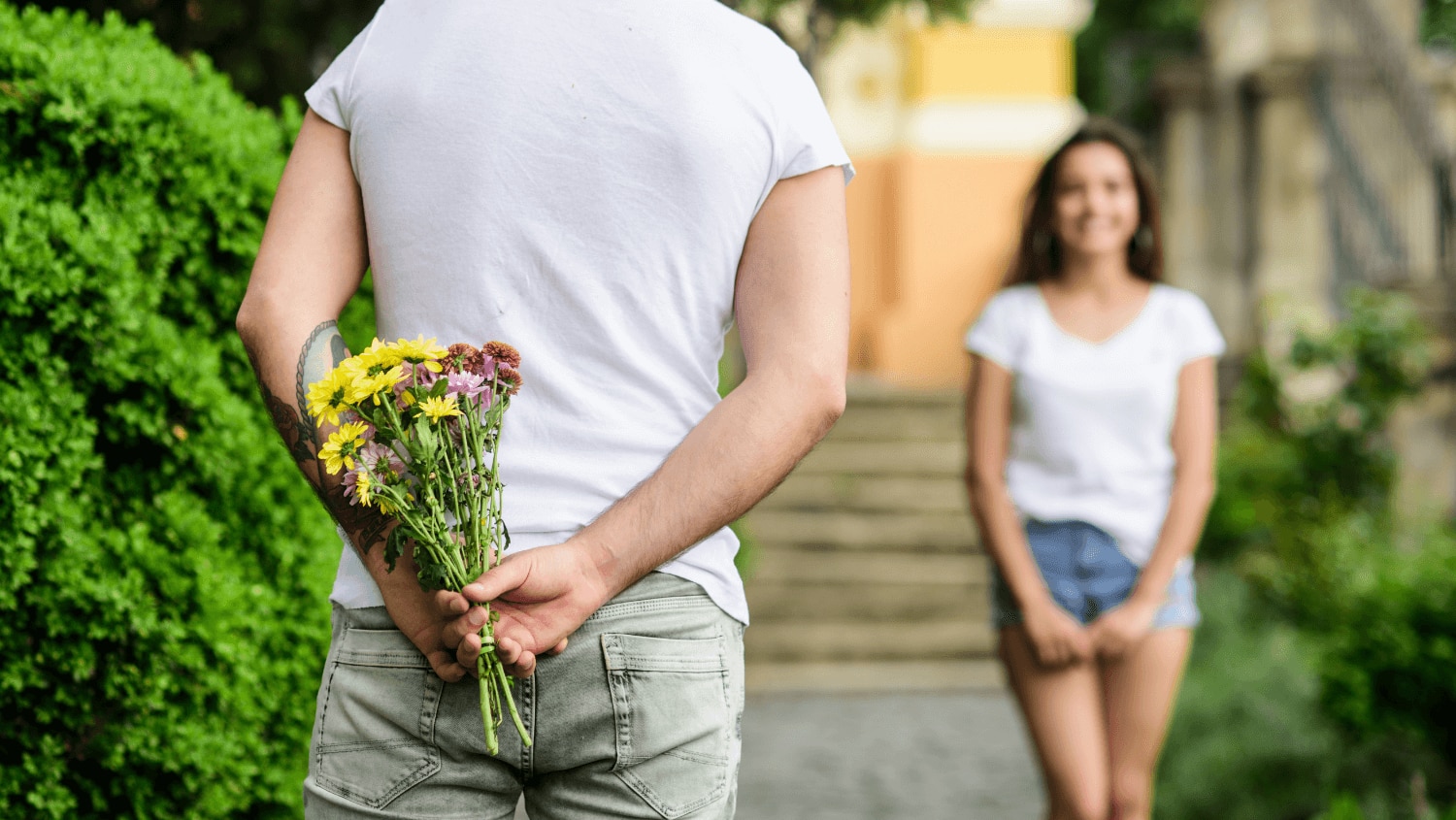 Young man holding flowers waiting for his first date to arrive 
