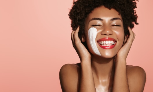 Beautiful African American woman using oatmeal to exfoliate her face
