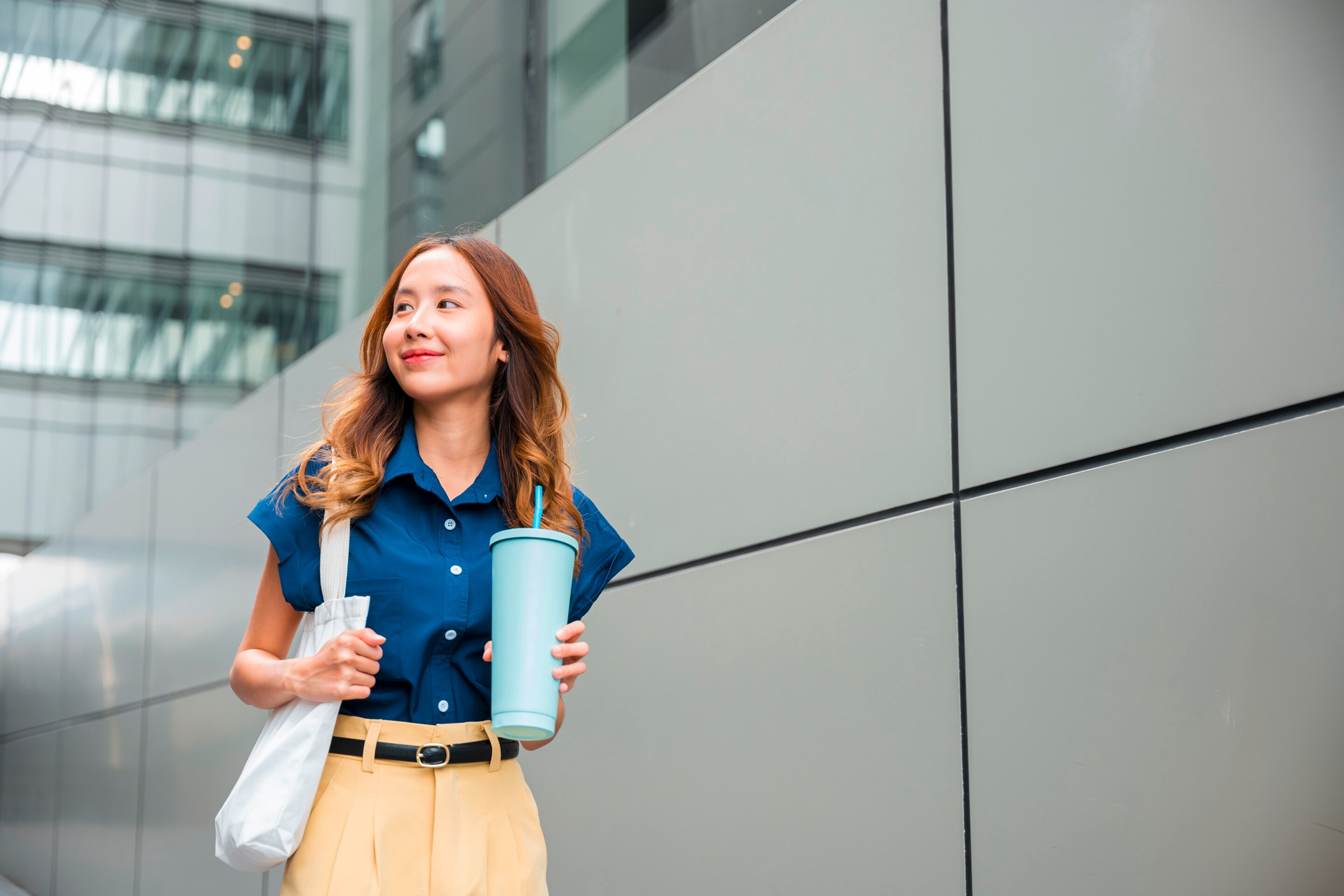Woman walking outside office building.
