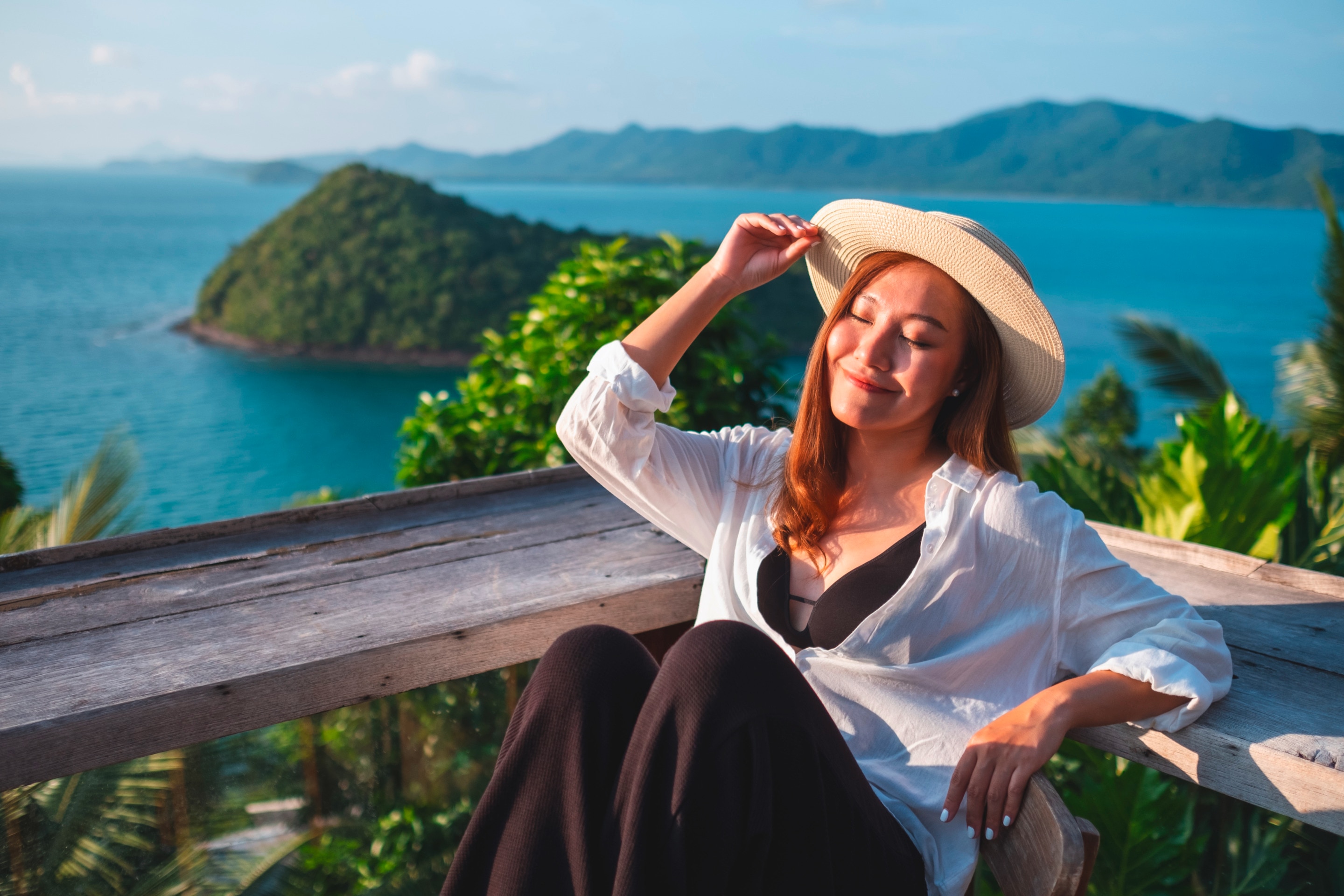 Woman enjoying the sun at a tropical resort.