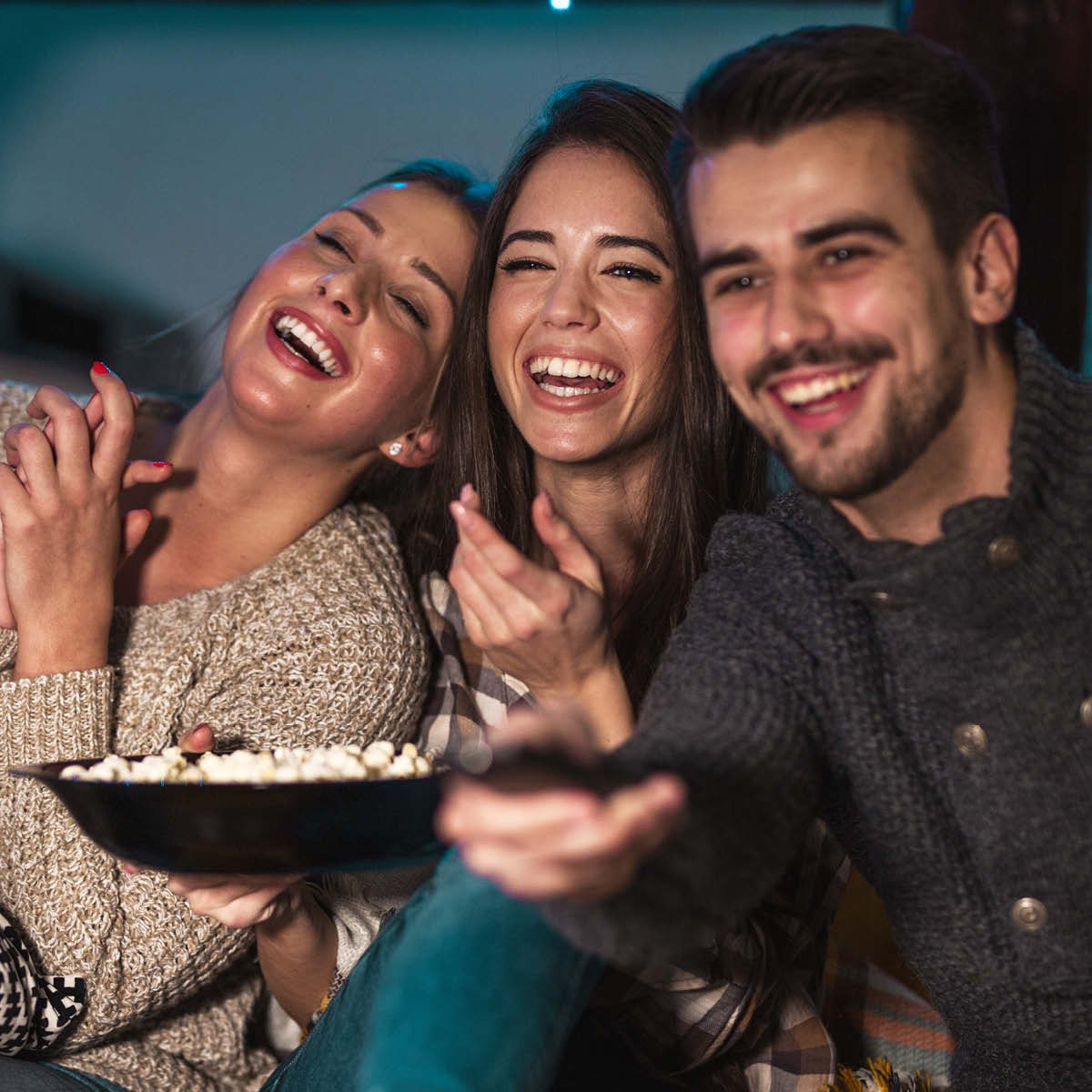 3 friends enjoying movie night desserts and popcorn