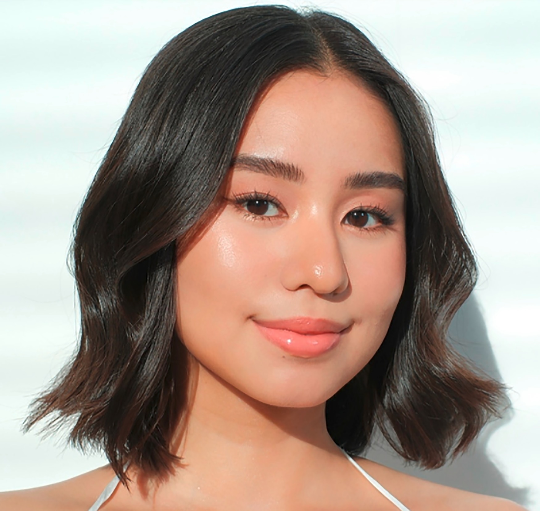 A Filipina influencer with a shoulder length wavy blunt bob.