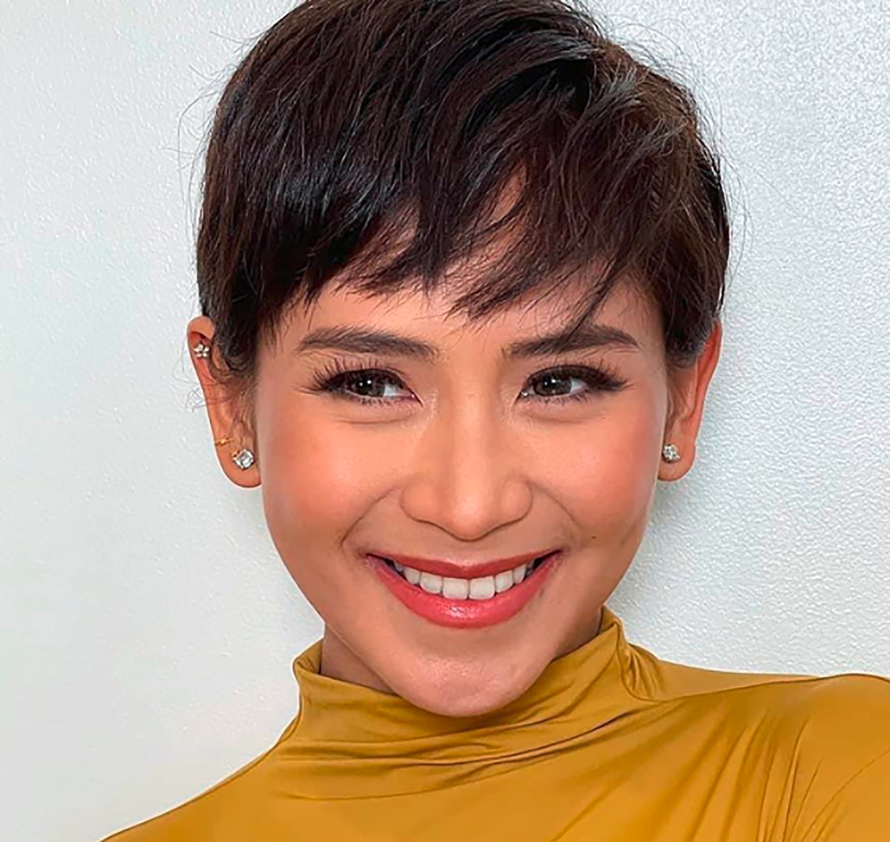 A Filipina actress with a cropped pixie cut.