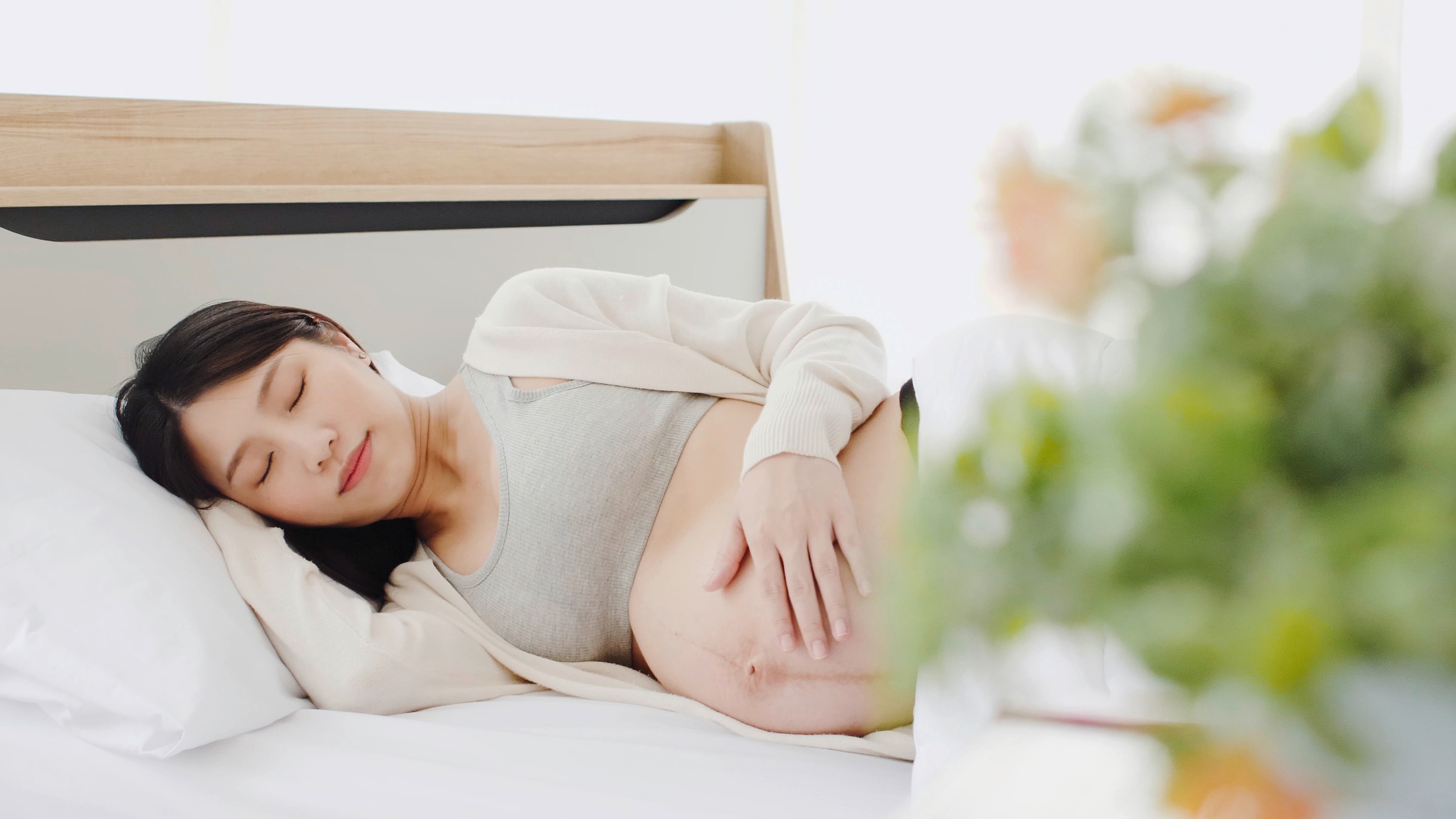 Ibu hamil sedang berbaring dengan posisi tidur miring agar bayi cepat lahir