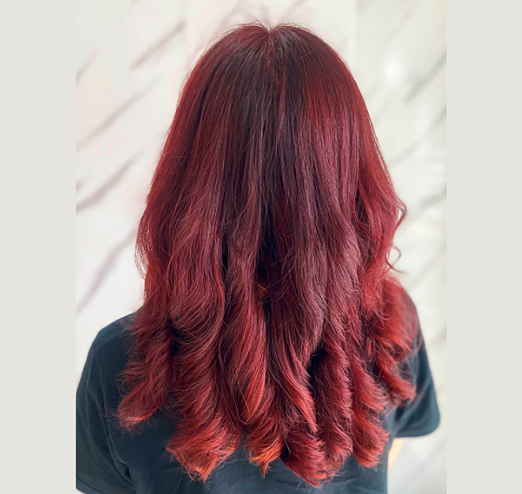 Back of a woman with burgundy hair.
