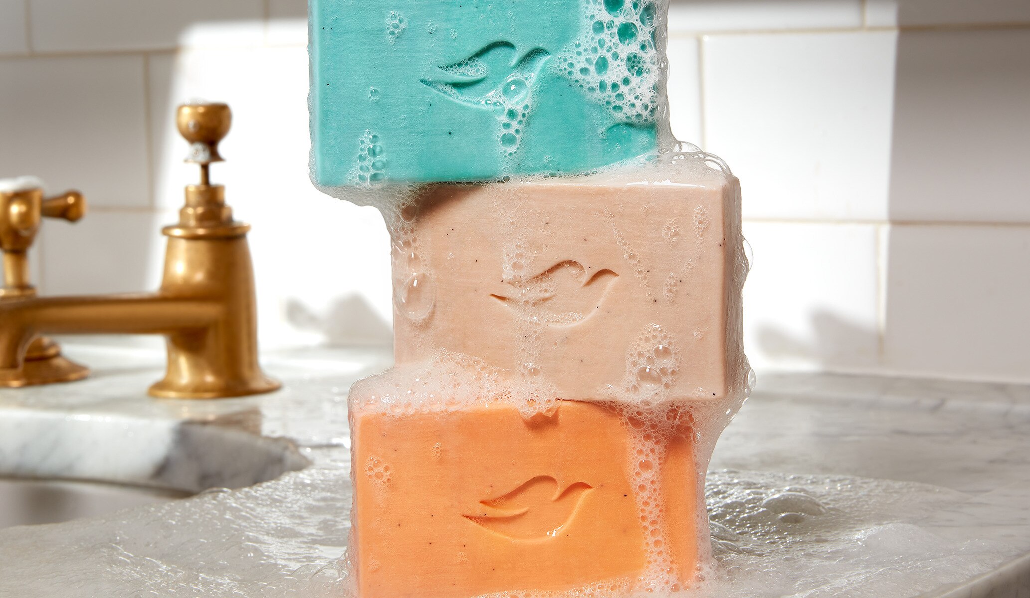 Image of three colourful Dove Men+Care soap bars stacked one on top of the other.