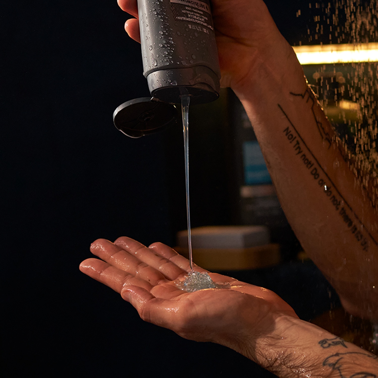 Male hand squeezing Dove Men+Care body wash into other hand