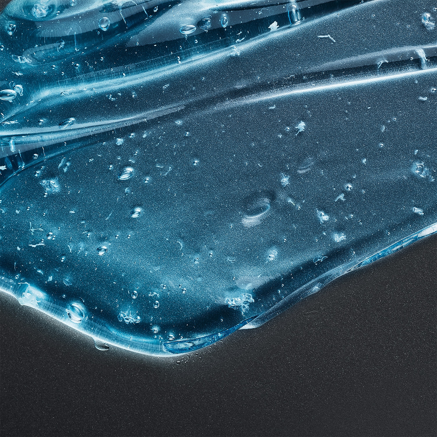 Blue translucent body wash texture against a dark background