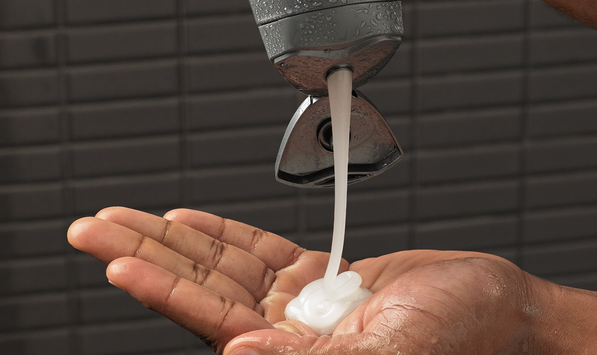 Hand squeezing Dove Men+Care shampoo onto hand