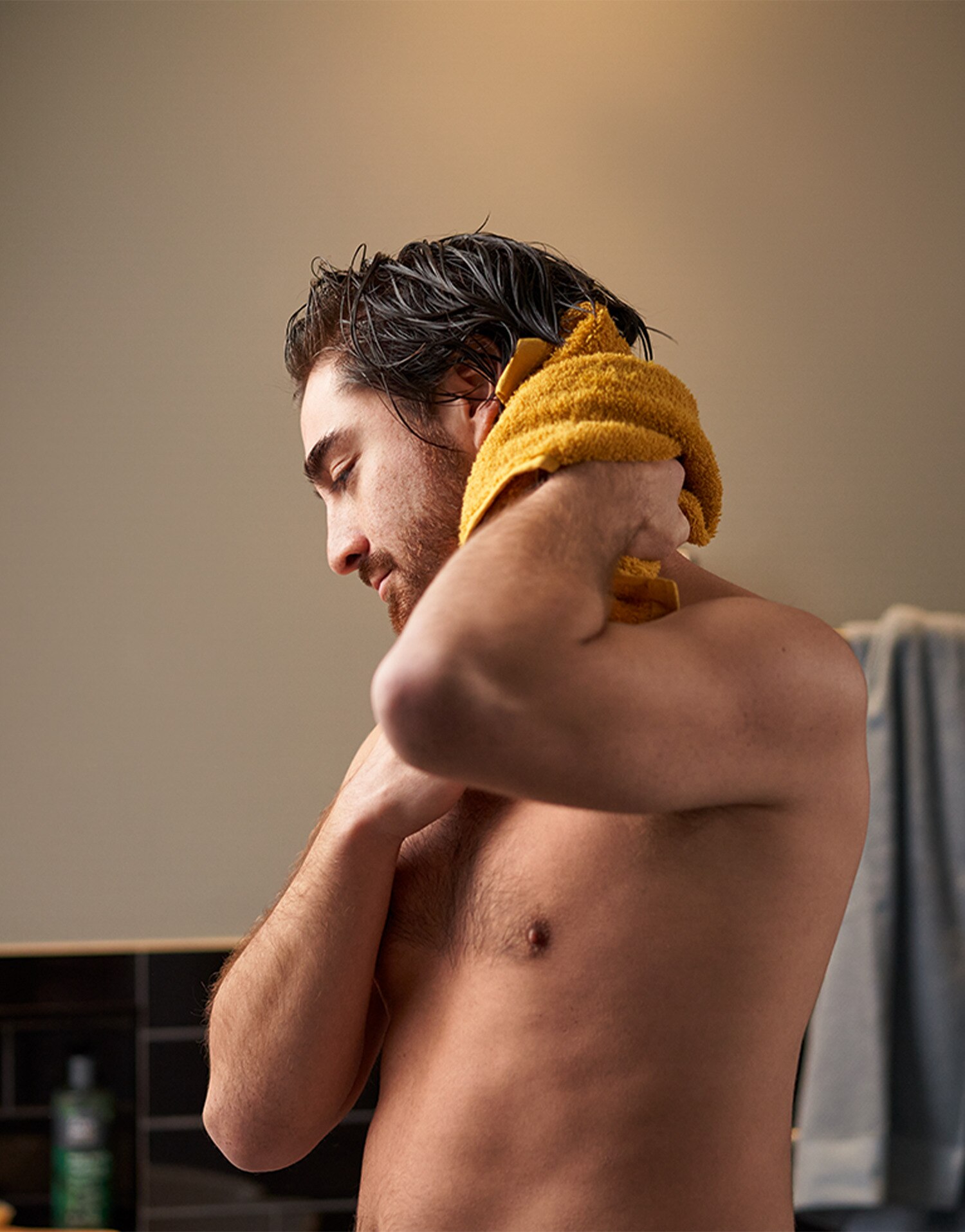 Man drying his neck with a yellow towel