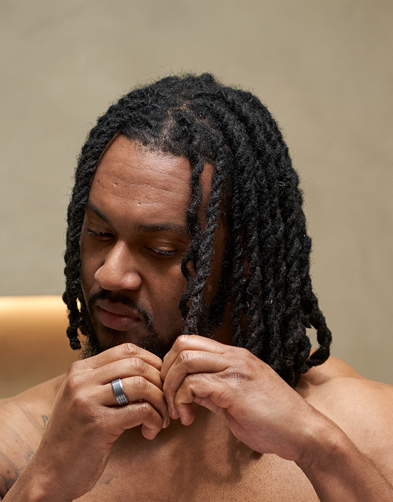 Image of a man braiding his textured hair.