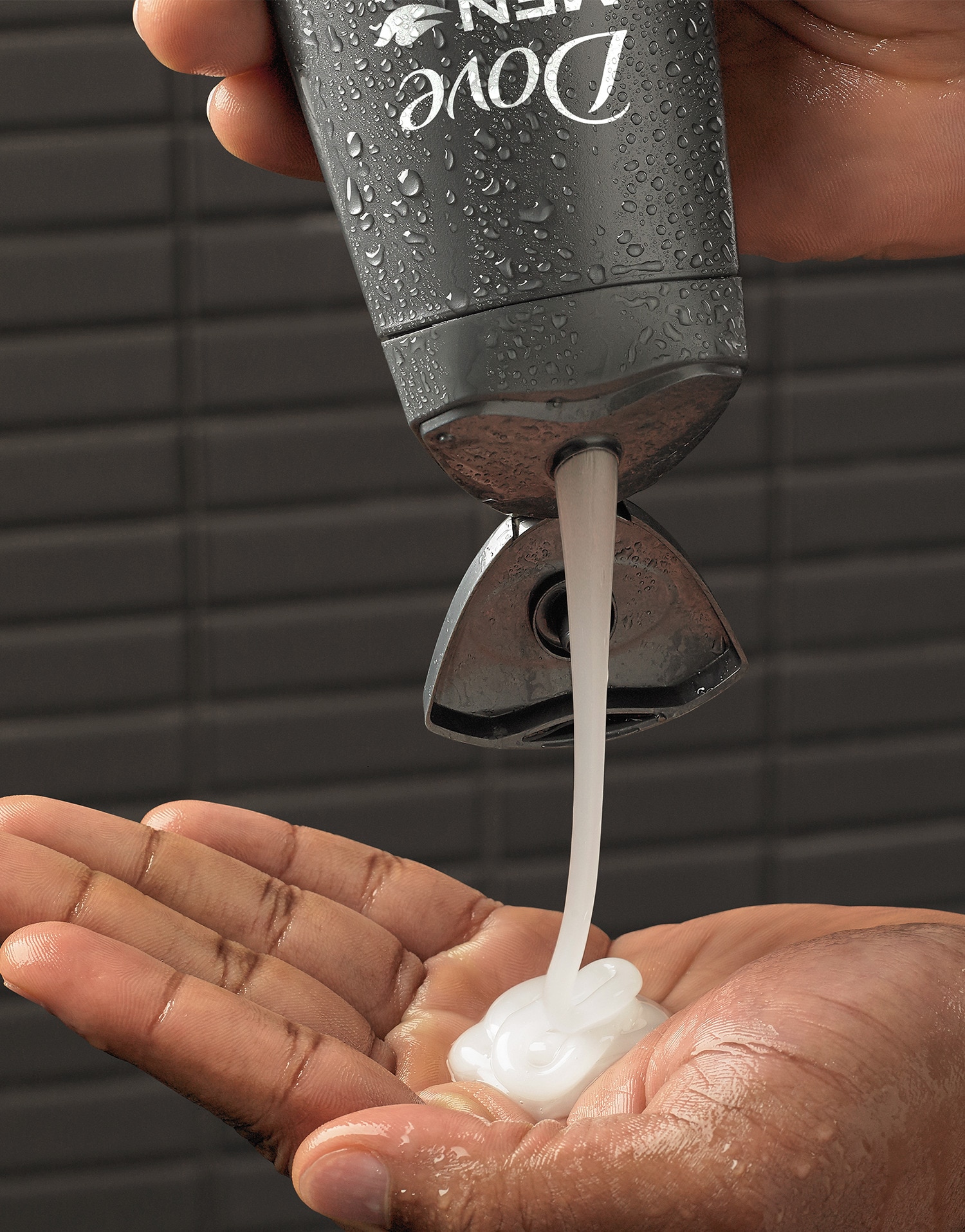 Man's hand squeezing Dove Men+Care shampoo product into his hand