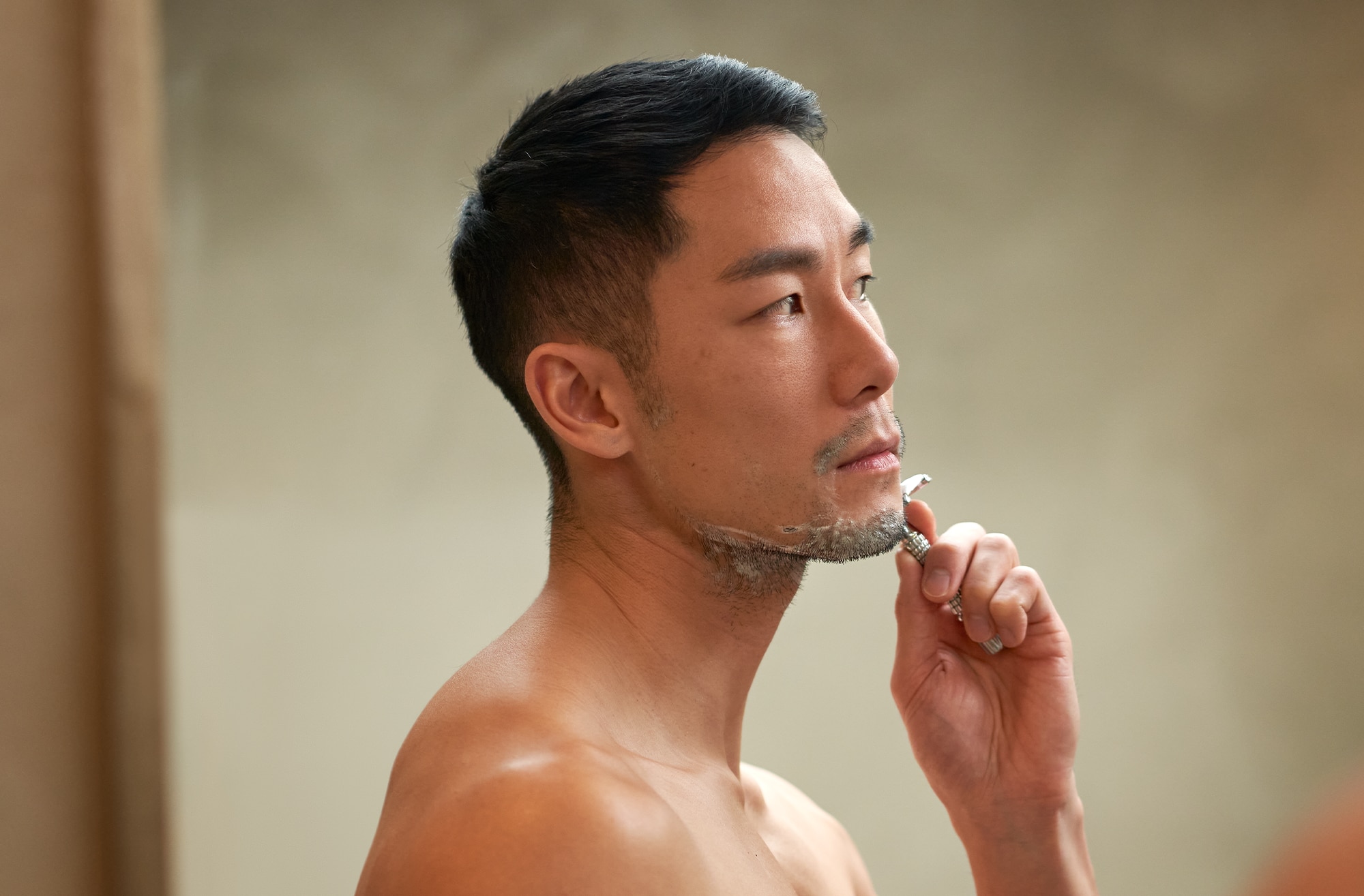 Man shaving his beard with a razor blade