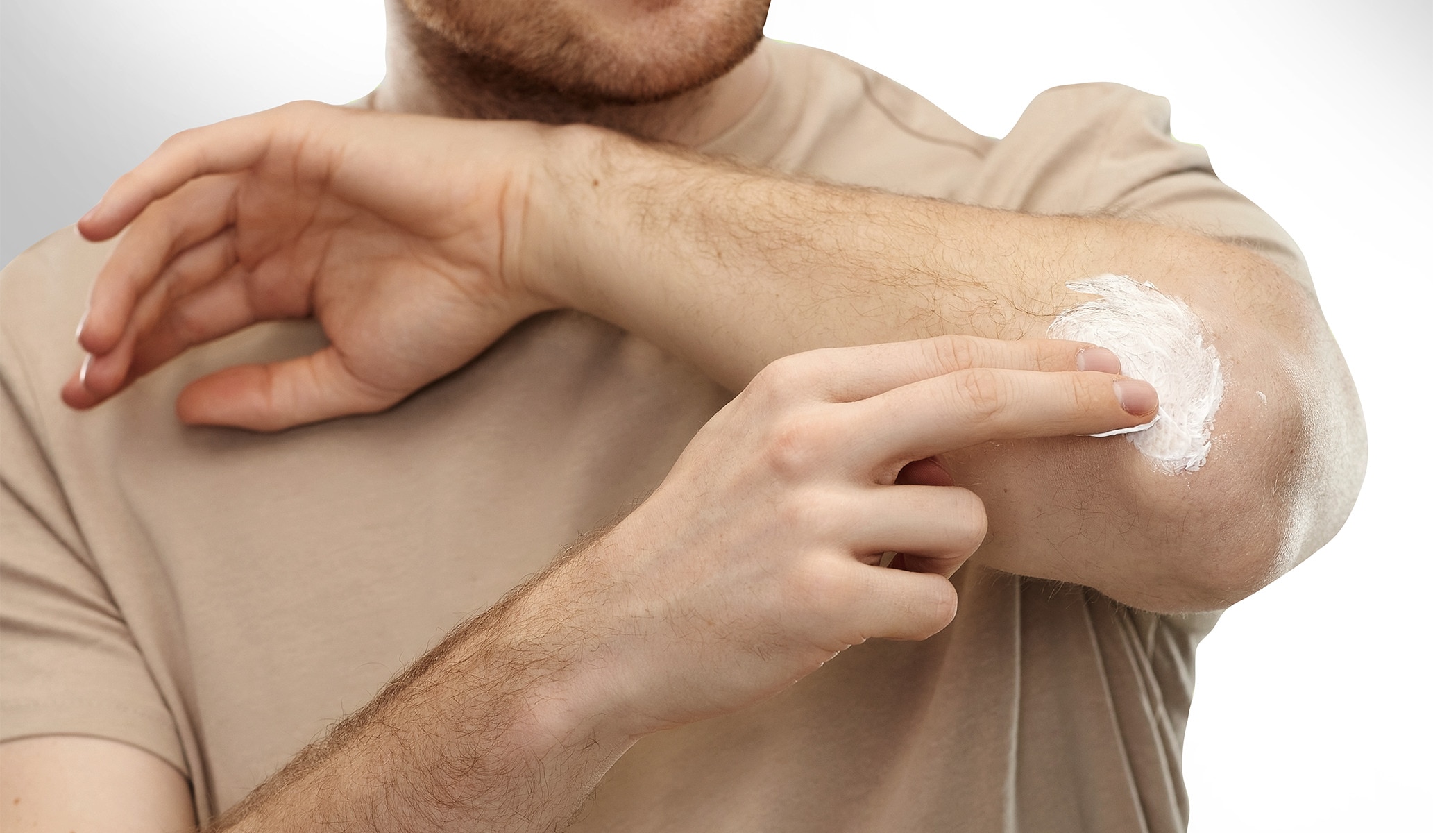 Man moisturizing his elbow