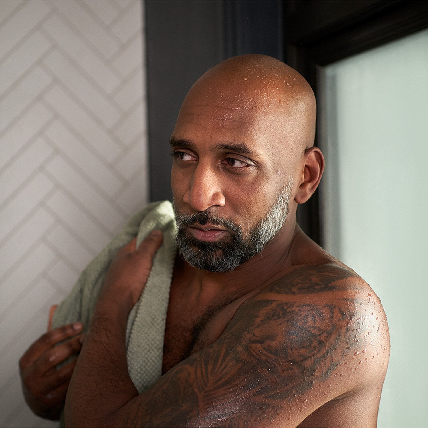 Tattooed man drying himself with a towel