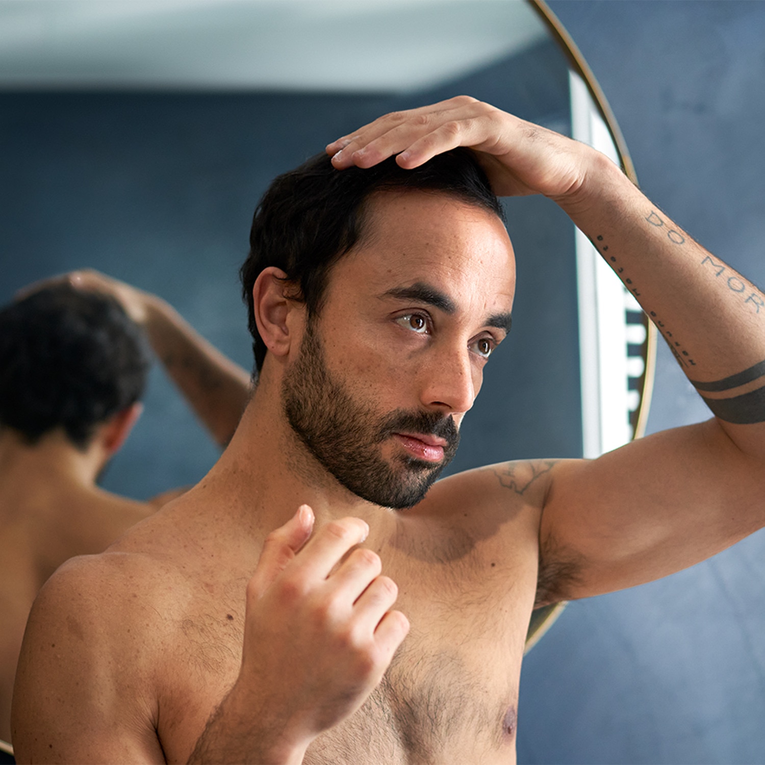 Man touching up his hair while looking in the mirror