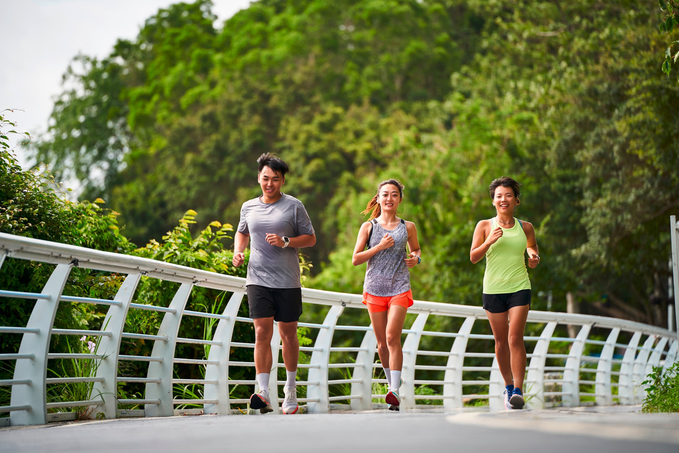 Man and two women running together.
