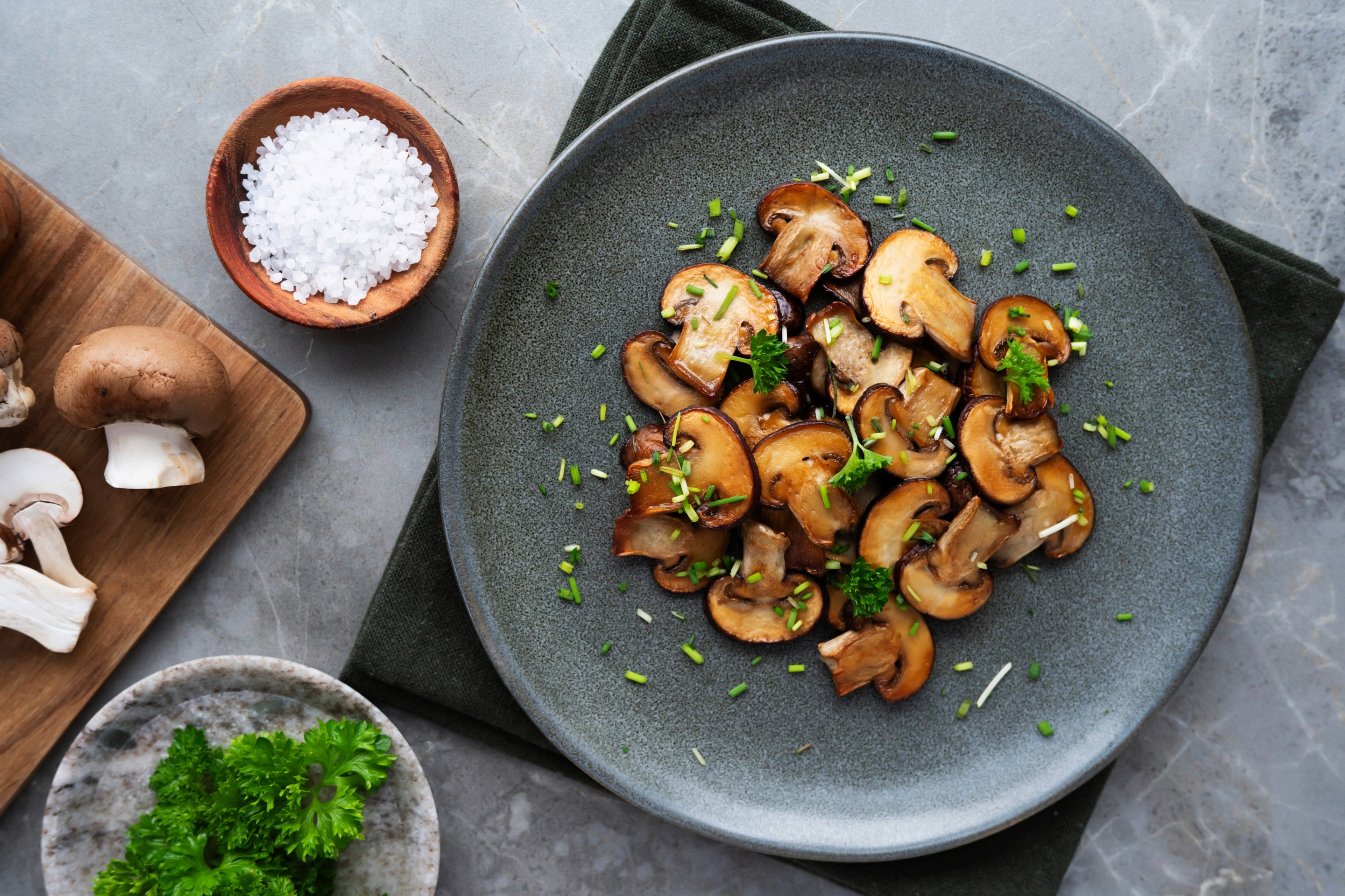 เห็ดหอมผัดโรยต้นหอม ในจานสีเทาเข้ม ถ้วยไม้ใส่เกลือเม็ด เห็ดหอมสด พาร์สเลย์