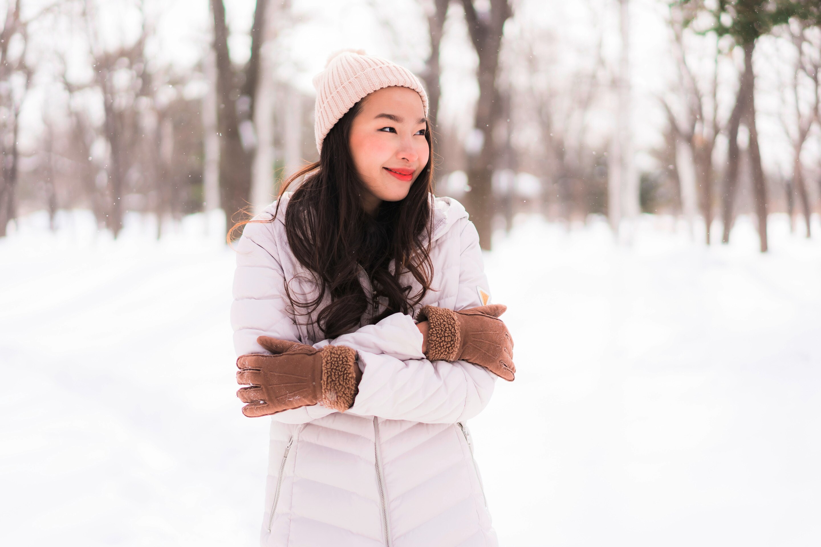 Happy Asian woman standing outdoors in the winter.