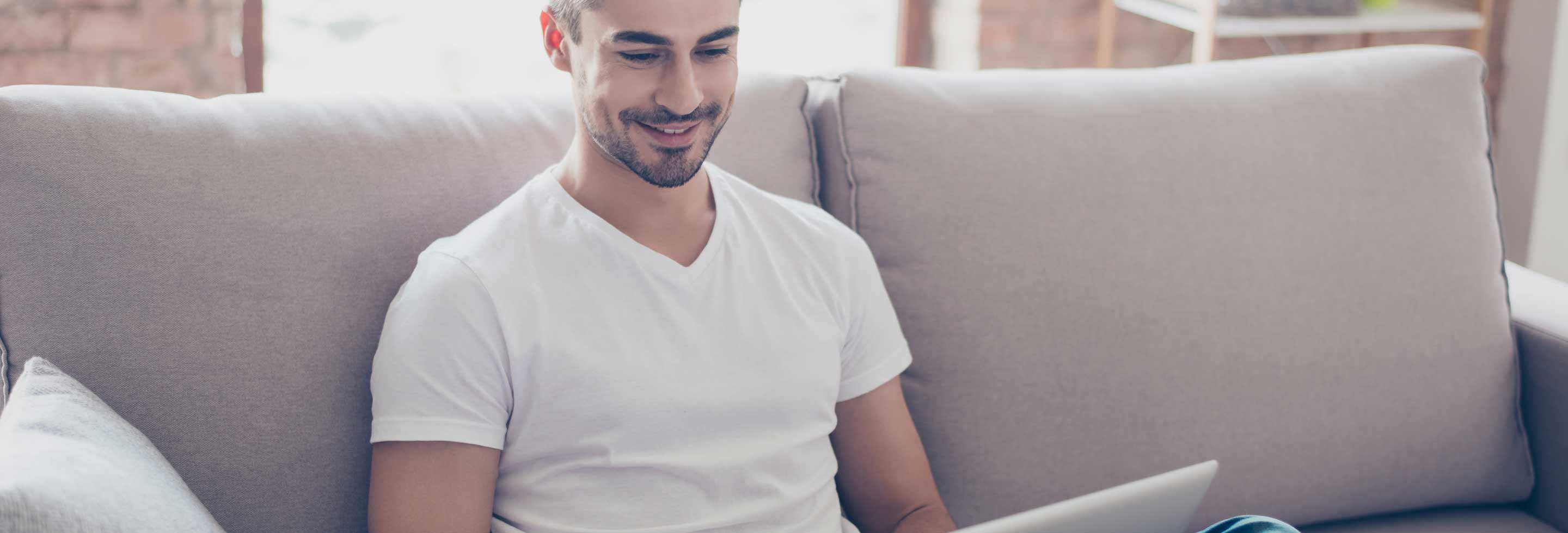 Young man working on his laptop wearing a long-lasting deodorant