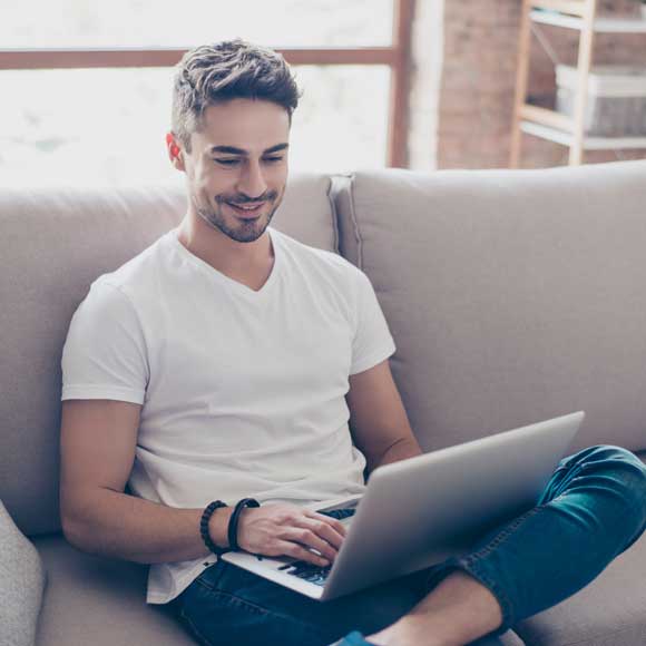 Young man working on his laptop wearing a long-lasting deodorant