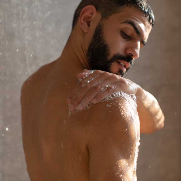 Thumbnail of young man in the shower with no sign of back acne