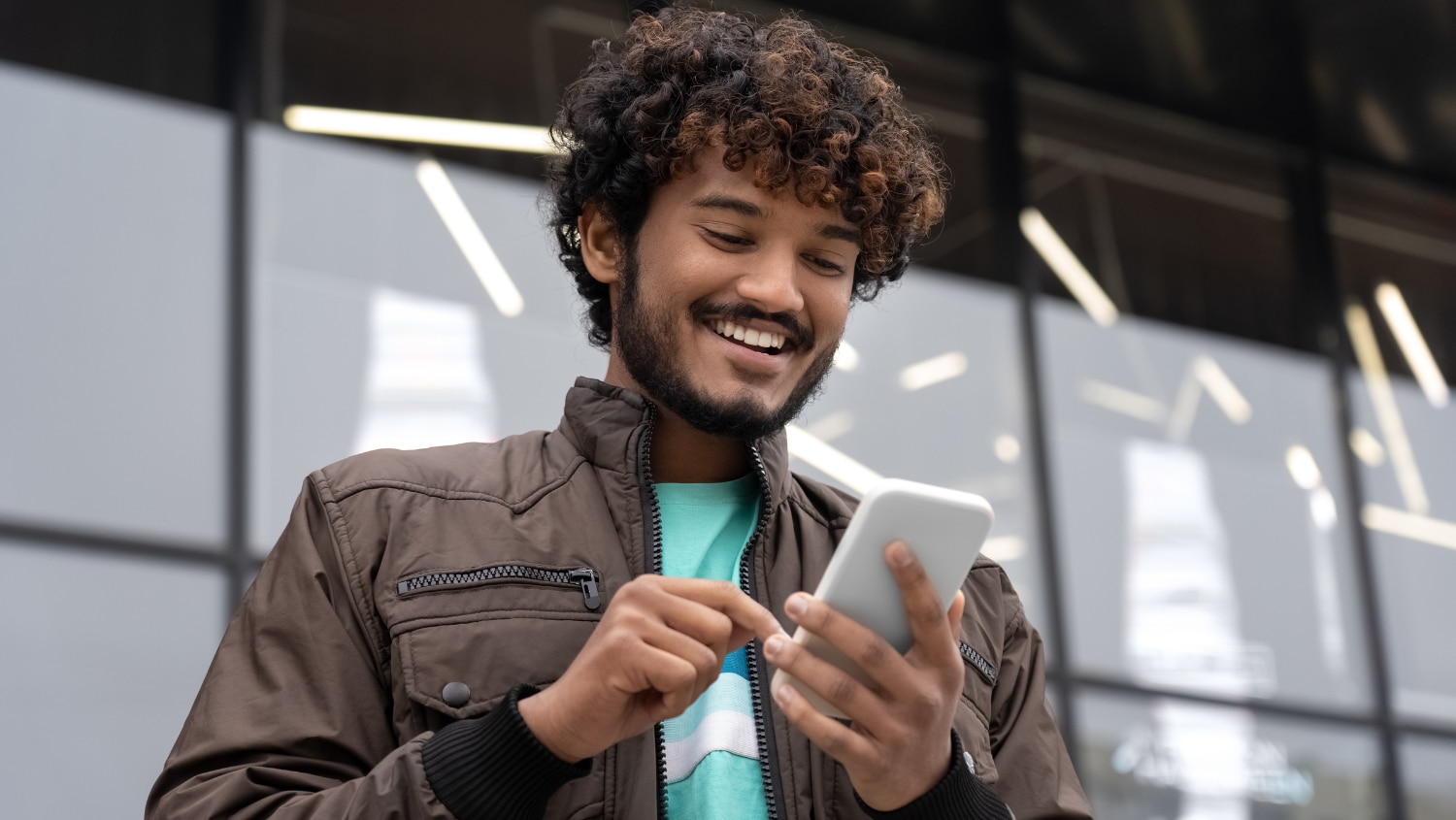 Young man looking at his phone sending a message to test his rizz.