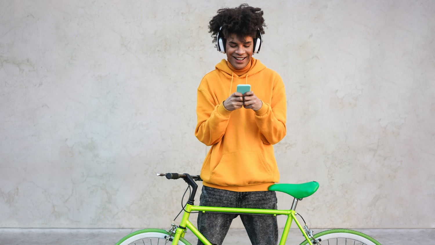 Young Gen Z male texting with his crush while waiting with his bike
