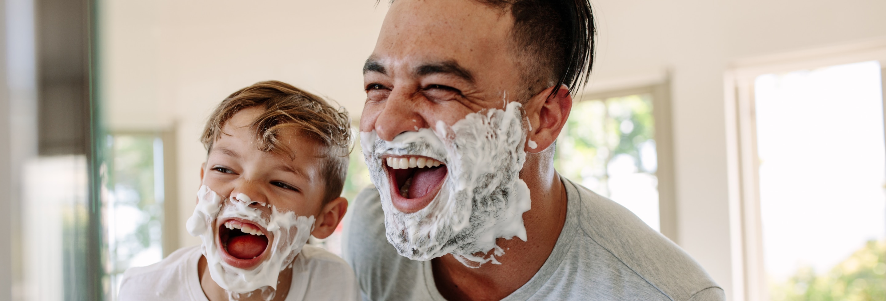 Father and son having fun shaving in the bathroom