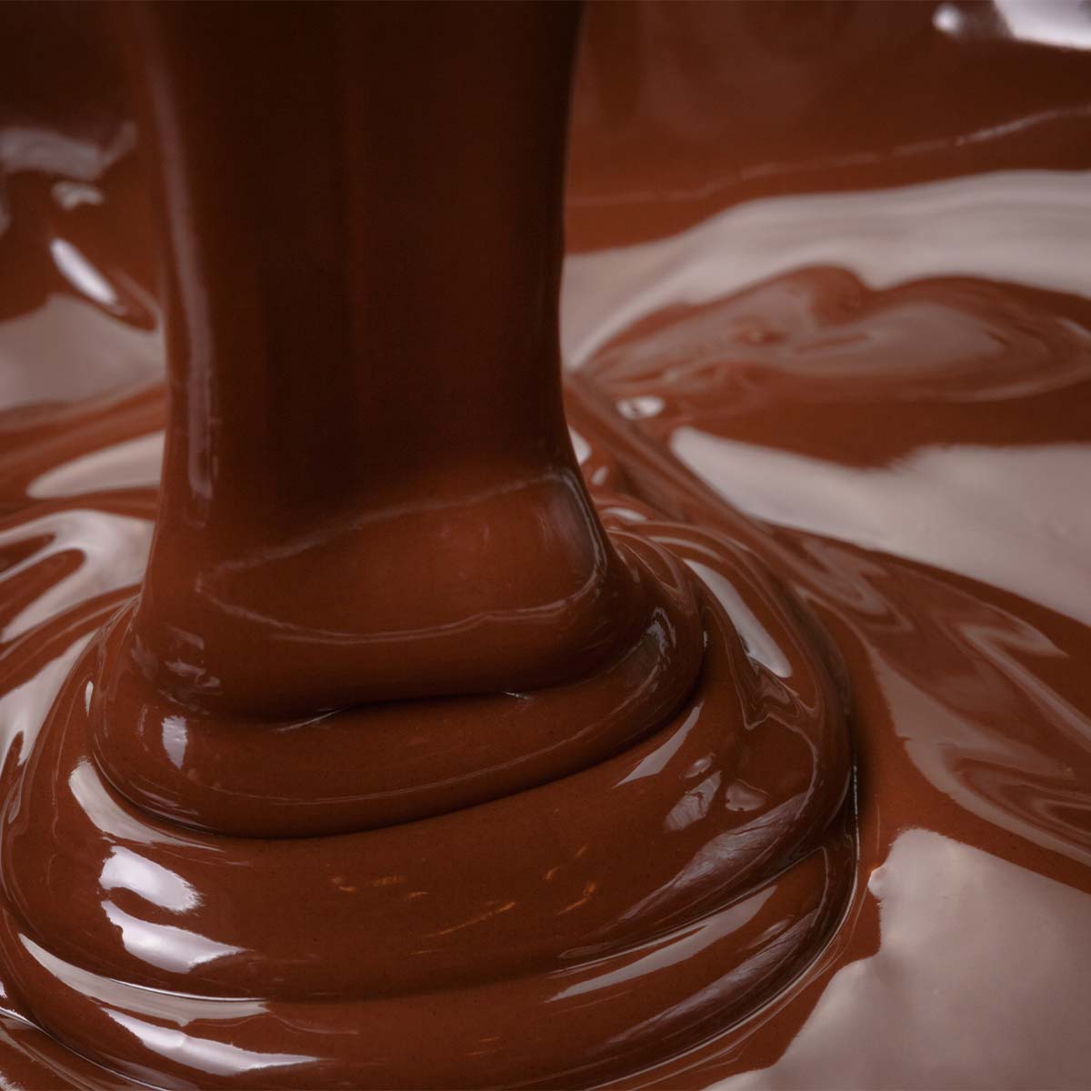 Close up of rich, glossy chocolate poured in a smooth, flowing motion