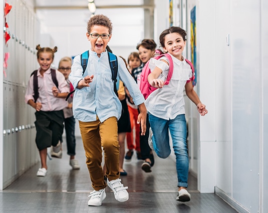Young children at school running through the hallway